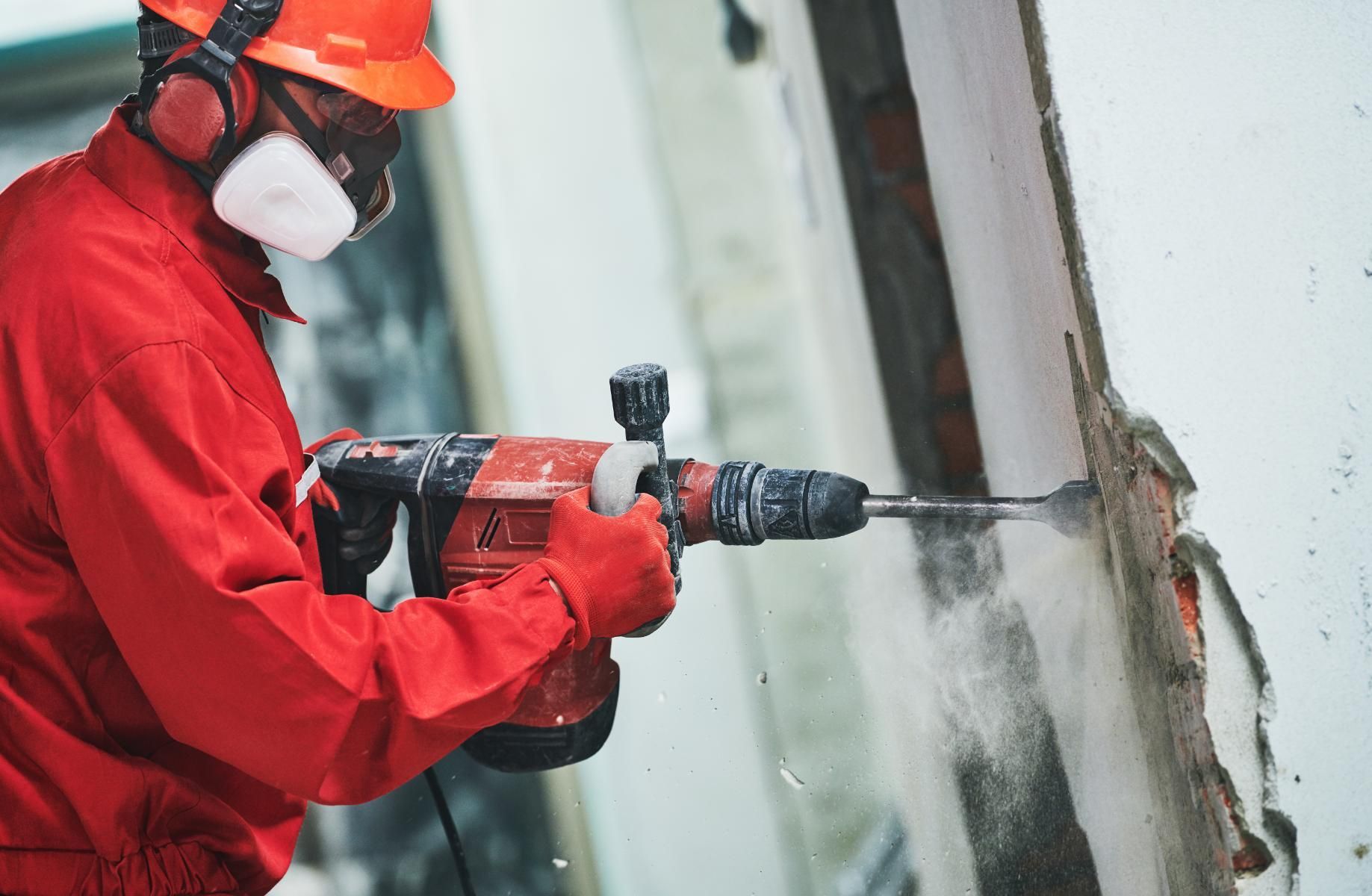 Construction Worker Drills Into a Wall — AB QUICK Painting & Maintenance Services In Mareeba, QLD