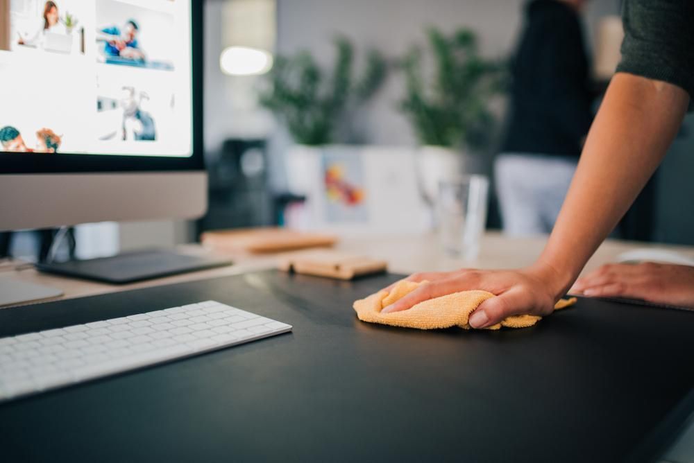 Person Wiping a Black Desk With a Yellow Cloth — AB QUICK Painting & Maintenance Services In Mareeba, QLD