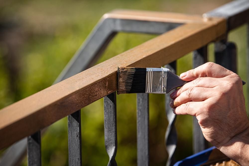 Person Painting a Brown Handrail — AB QUICK Painting & Maintenance Services In Mareeba, QLD