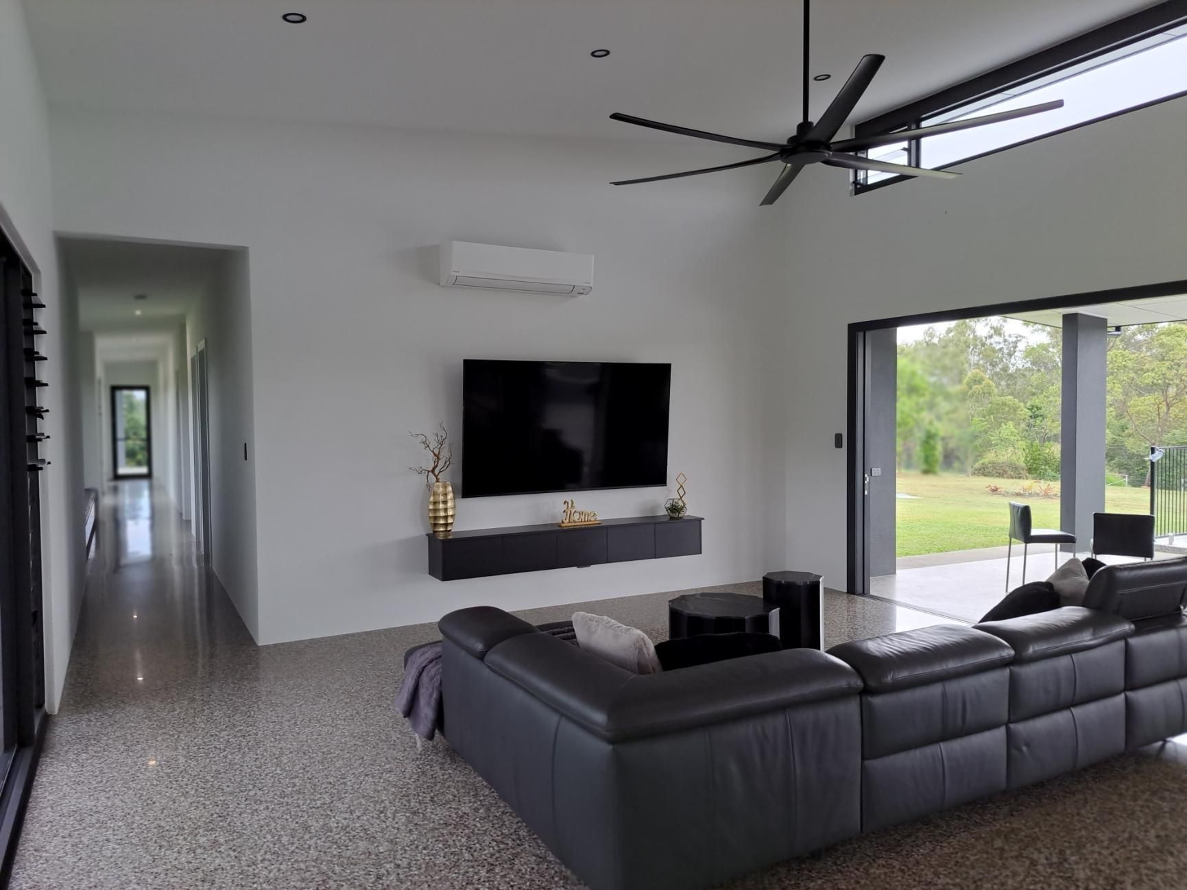 Modern Living Room With a Large TV, And Gray Sectional Sofa — AB QUICK Painting & Maintenance Services In Mareeba, QLD
