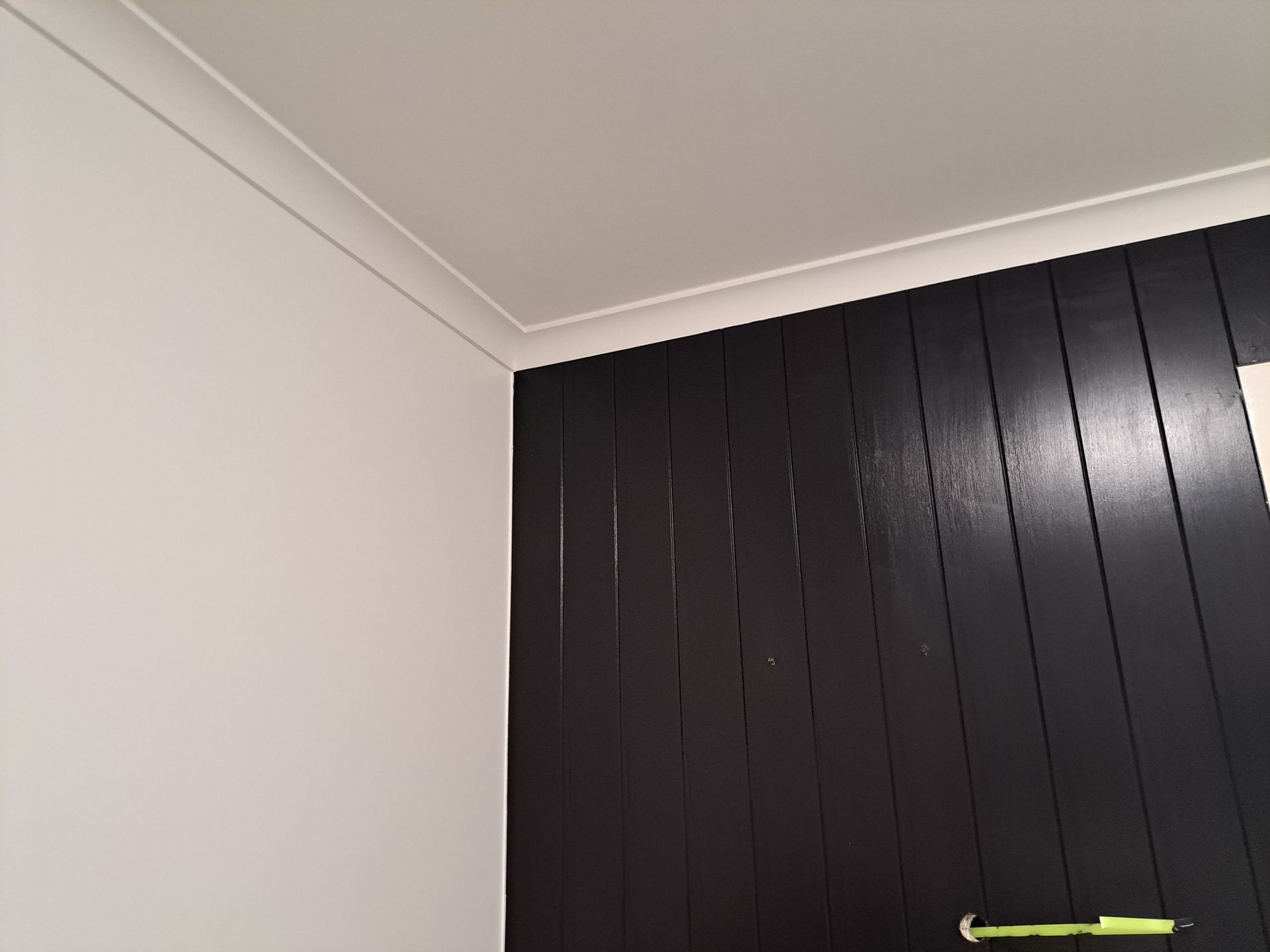 Corner of a room: white ceiling and wall, black vertical wooden panel wall, white molding — AB QUICK Painting & Maintenance Services In Mareeba, QLD
