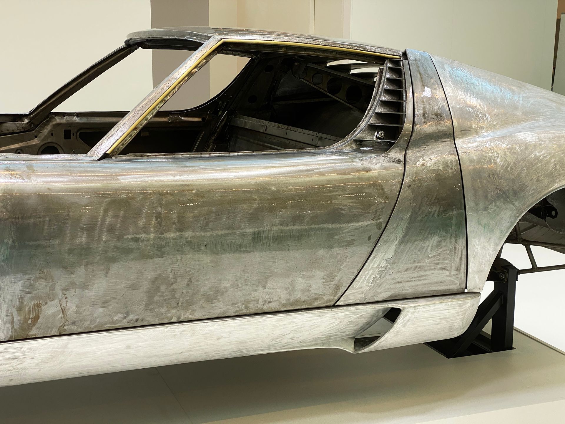 Partially assembled silver sports car body in a workshop display Partially assembled silver sports car body in a workshop display