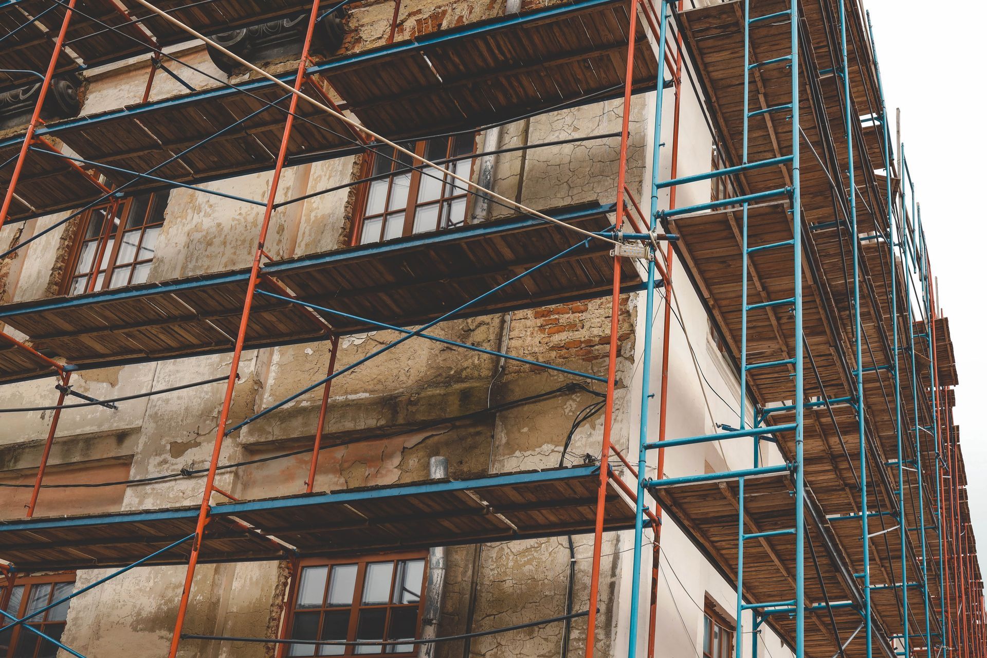 Scaffolding around a weathered multi-story building facade under renovation