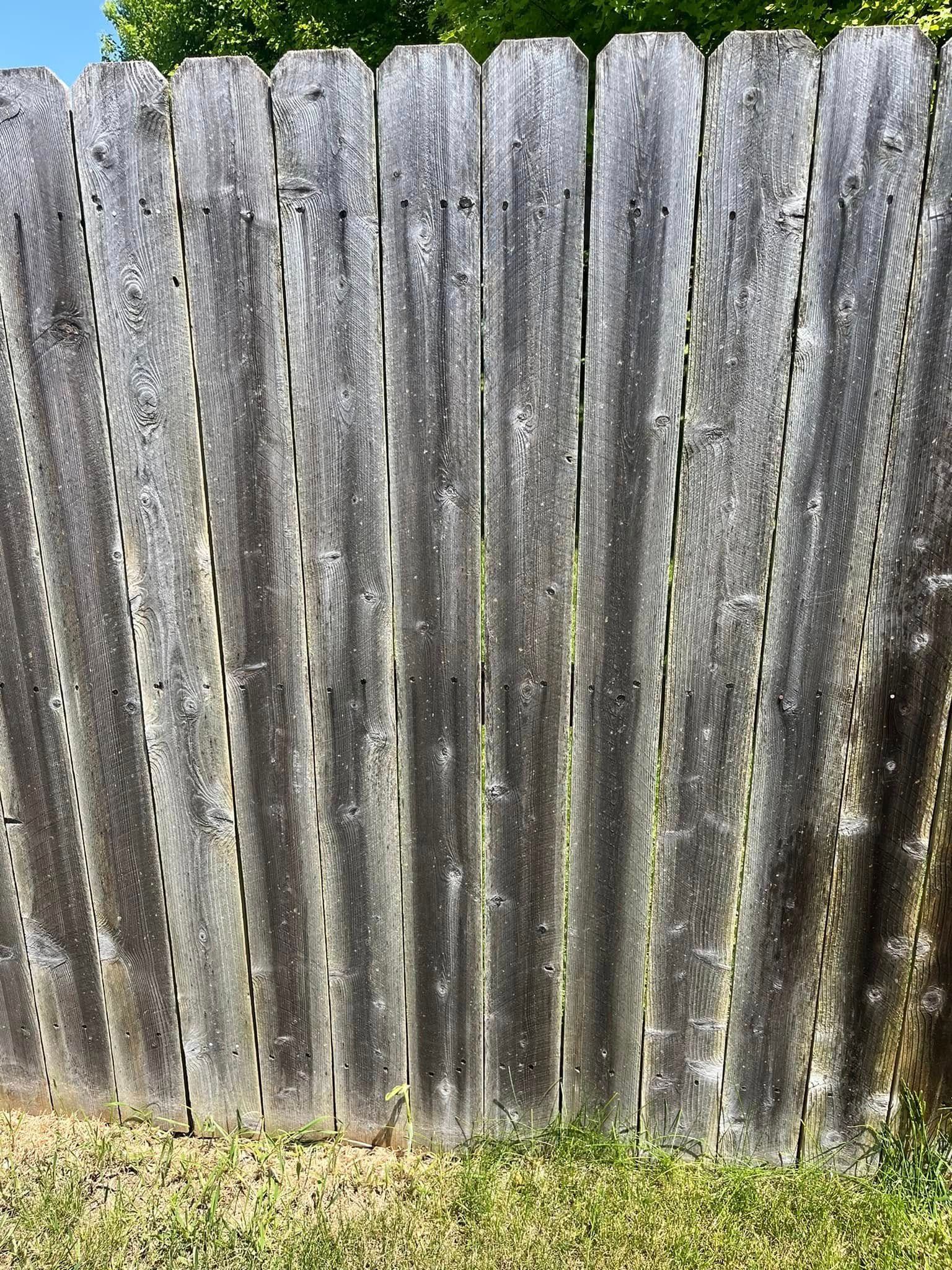 A close up of a wooden fence in the grass.
