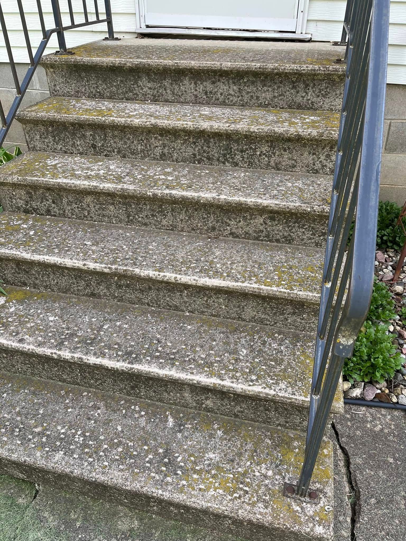 A set of stairs leading up to a house with a railing.