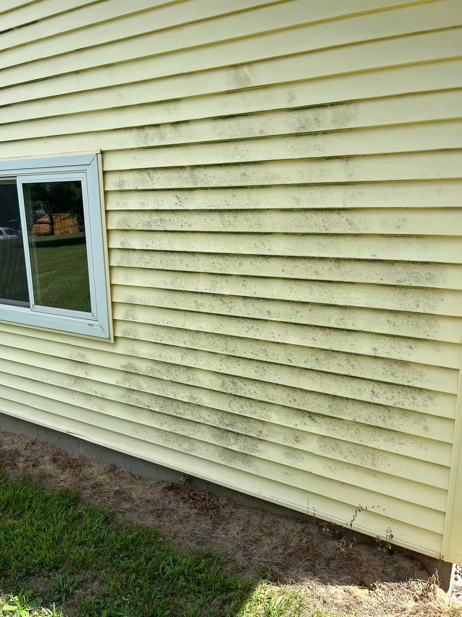 A yellow house with a window on the side of it.