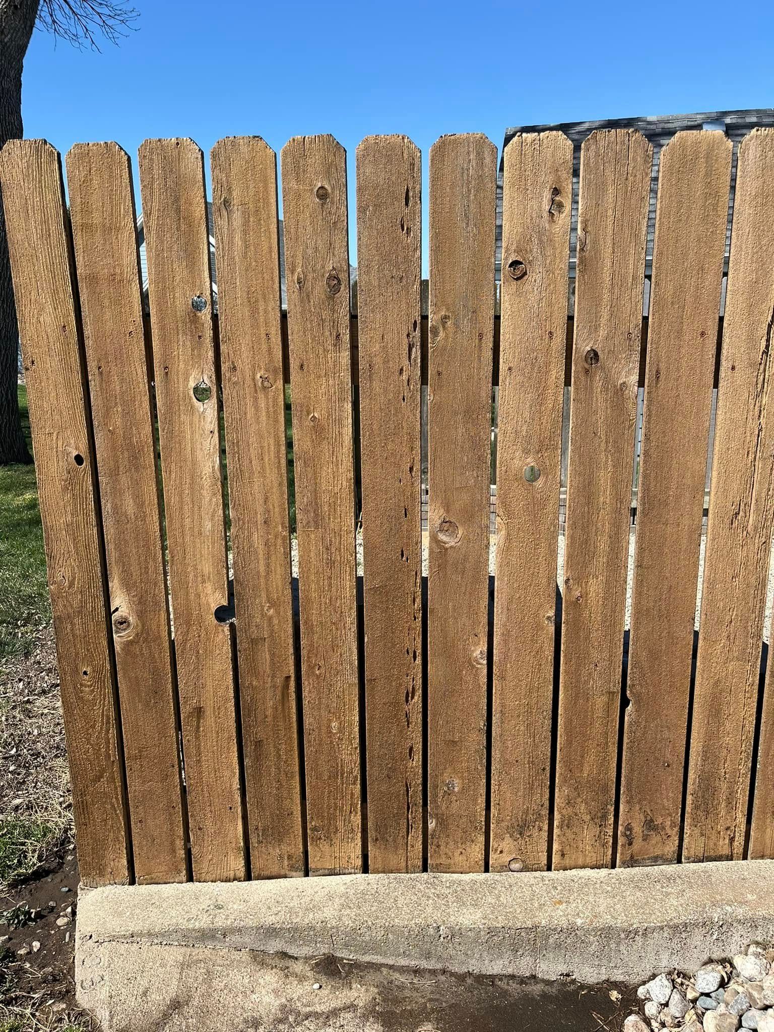 A wooden fence is sitting on top of a concrete block.
