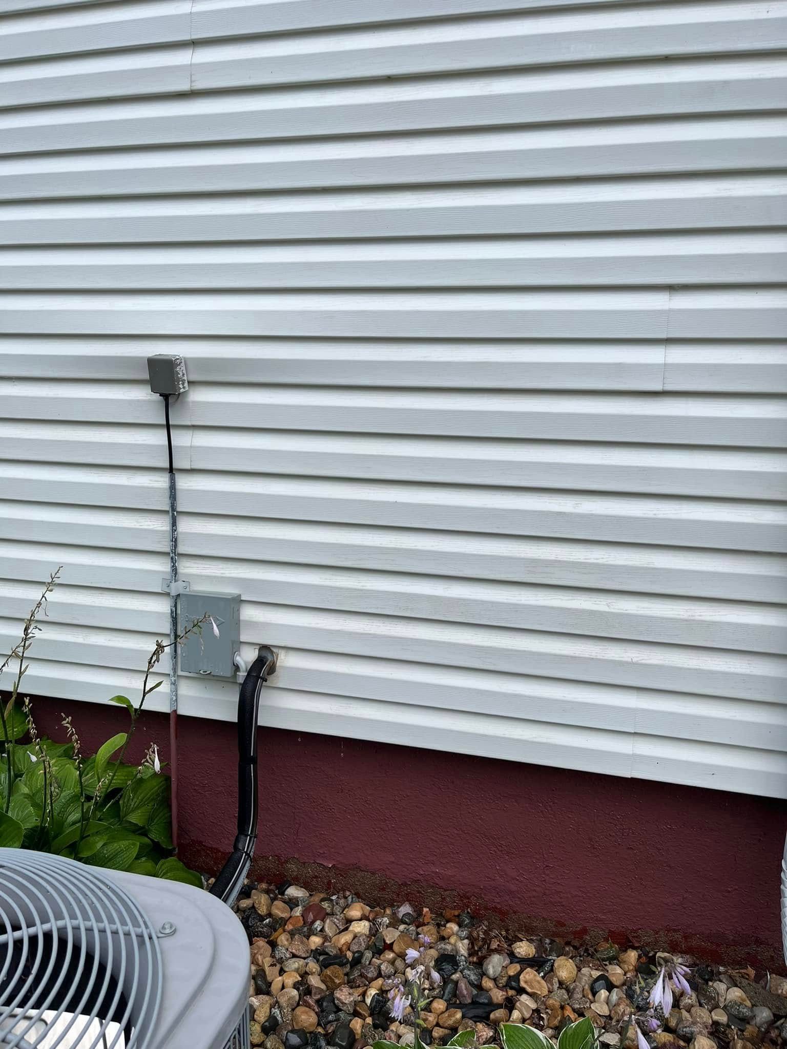 A white house with a gray air conditioner on the side of it.