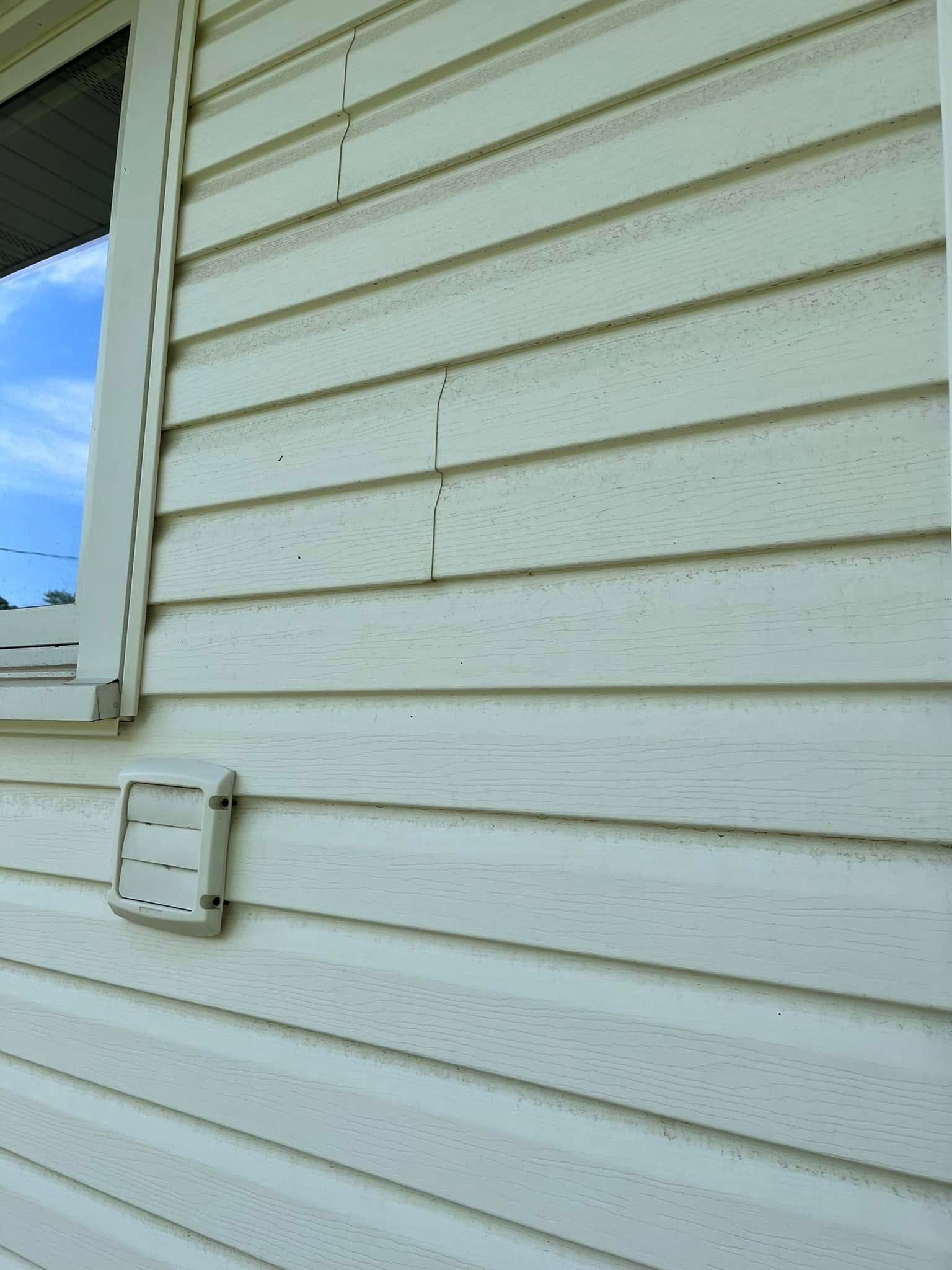 A white house with a window and a white siding.