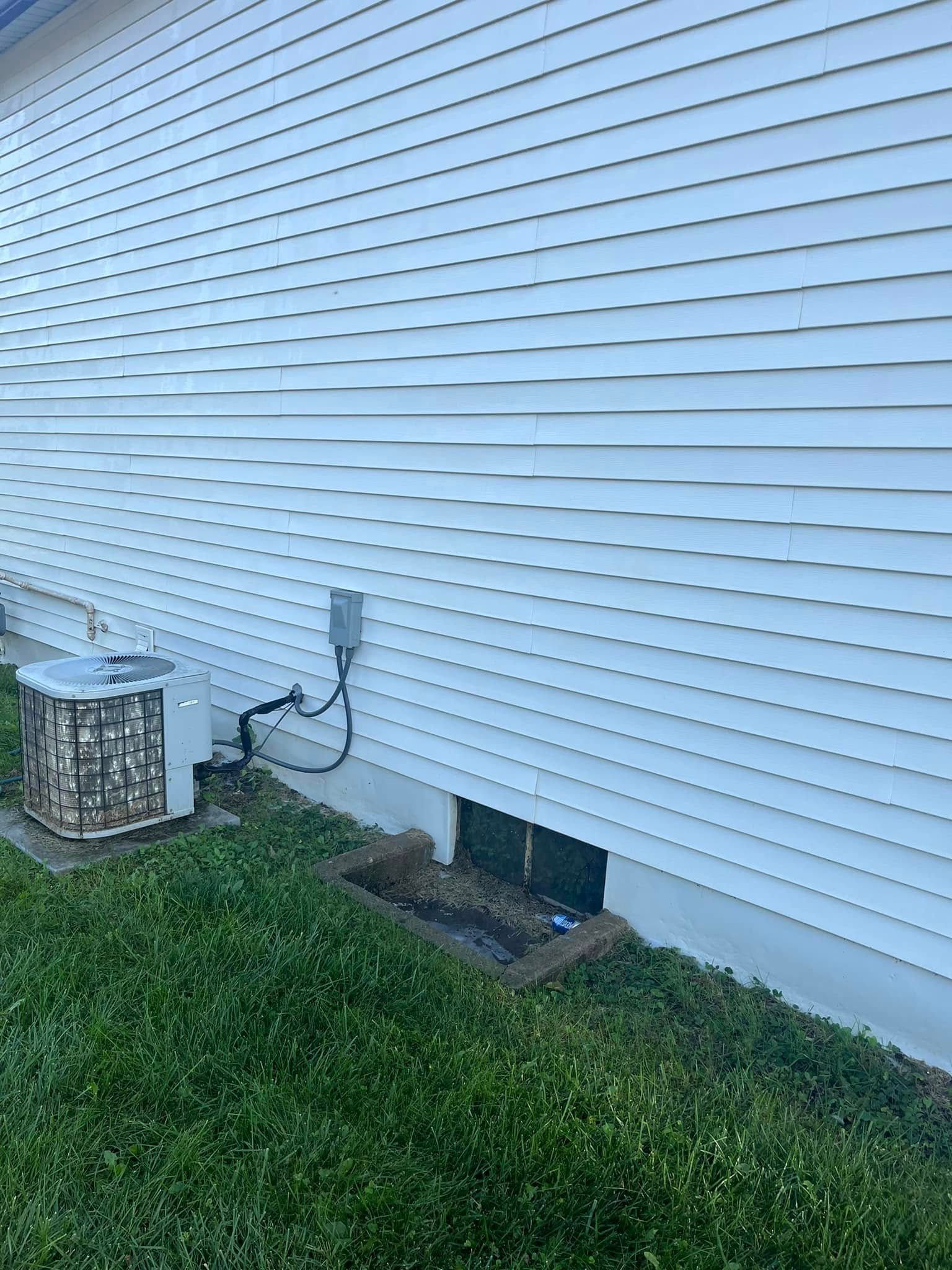 A white house with a air conditioner on the side of it.