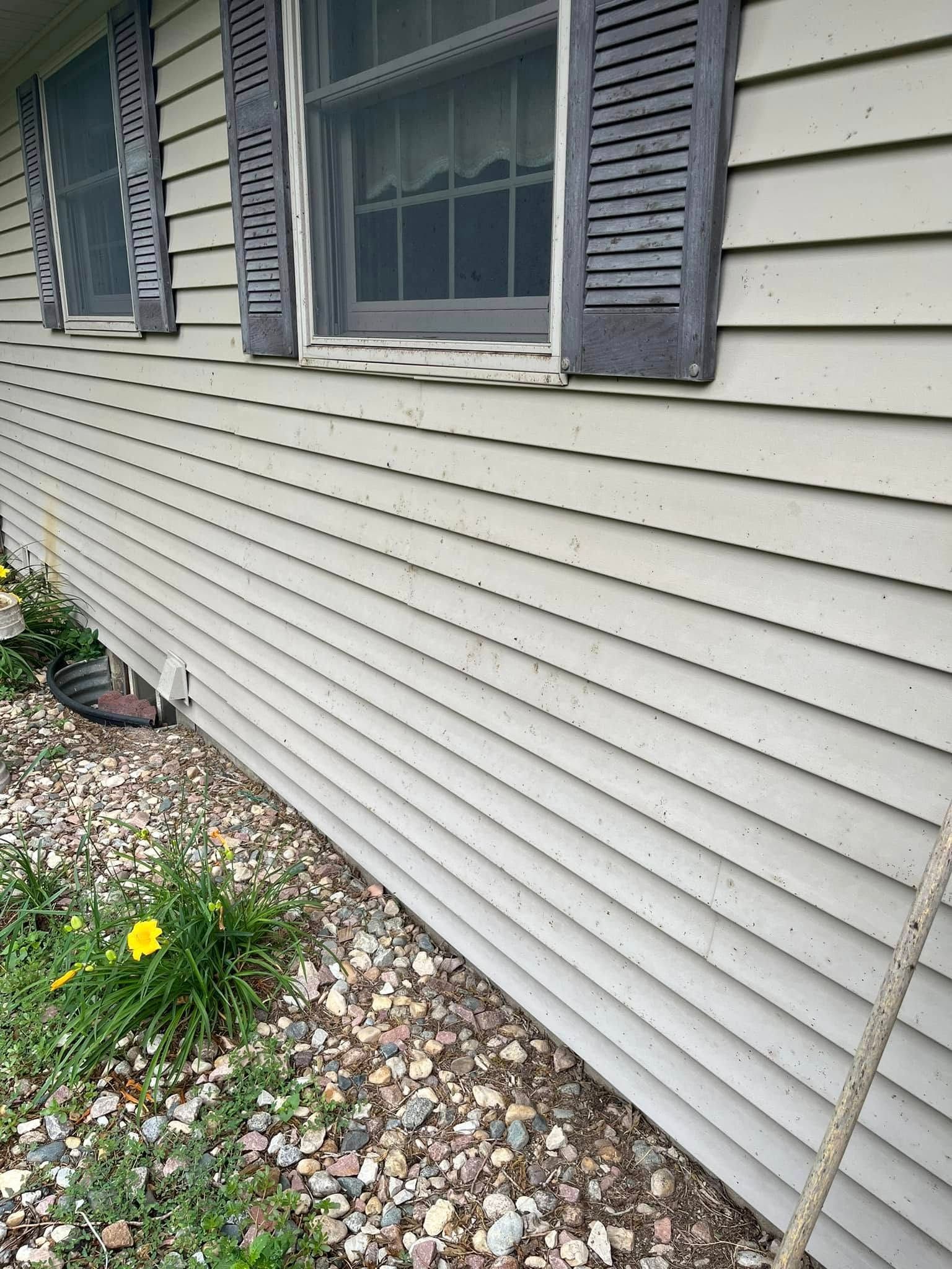 The side of a house with a lot of windows and shutters.