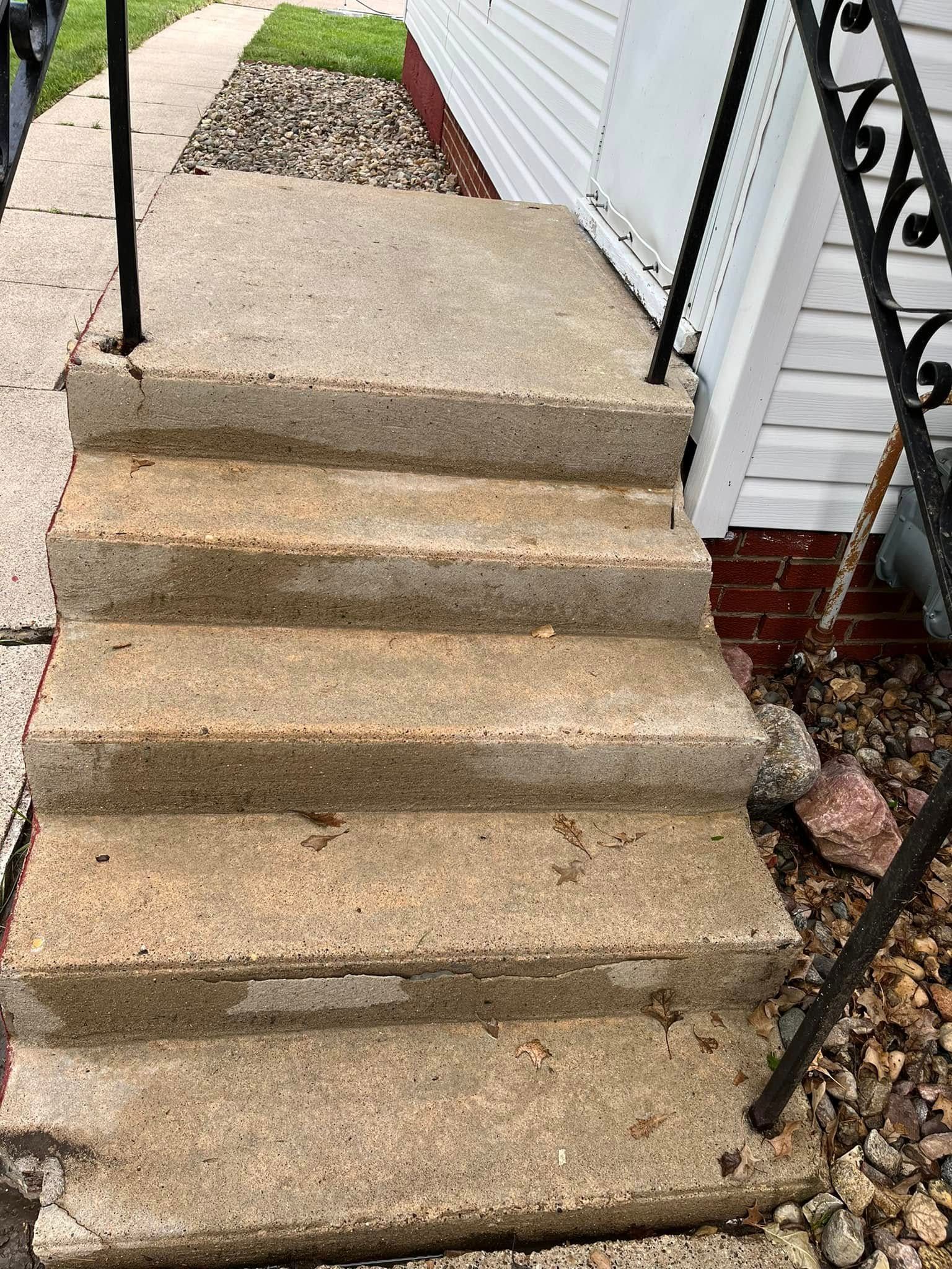 A set of concrete stairs leading up to a house.