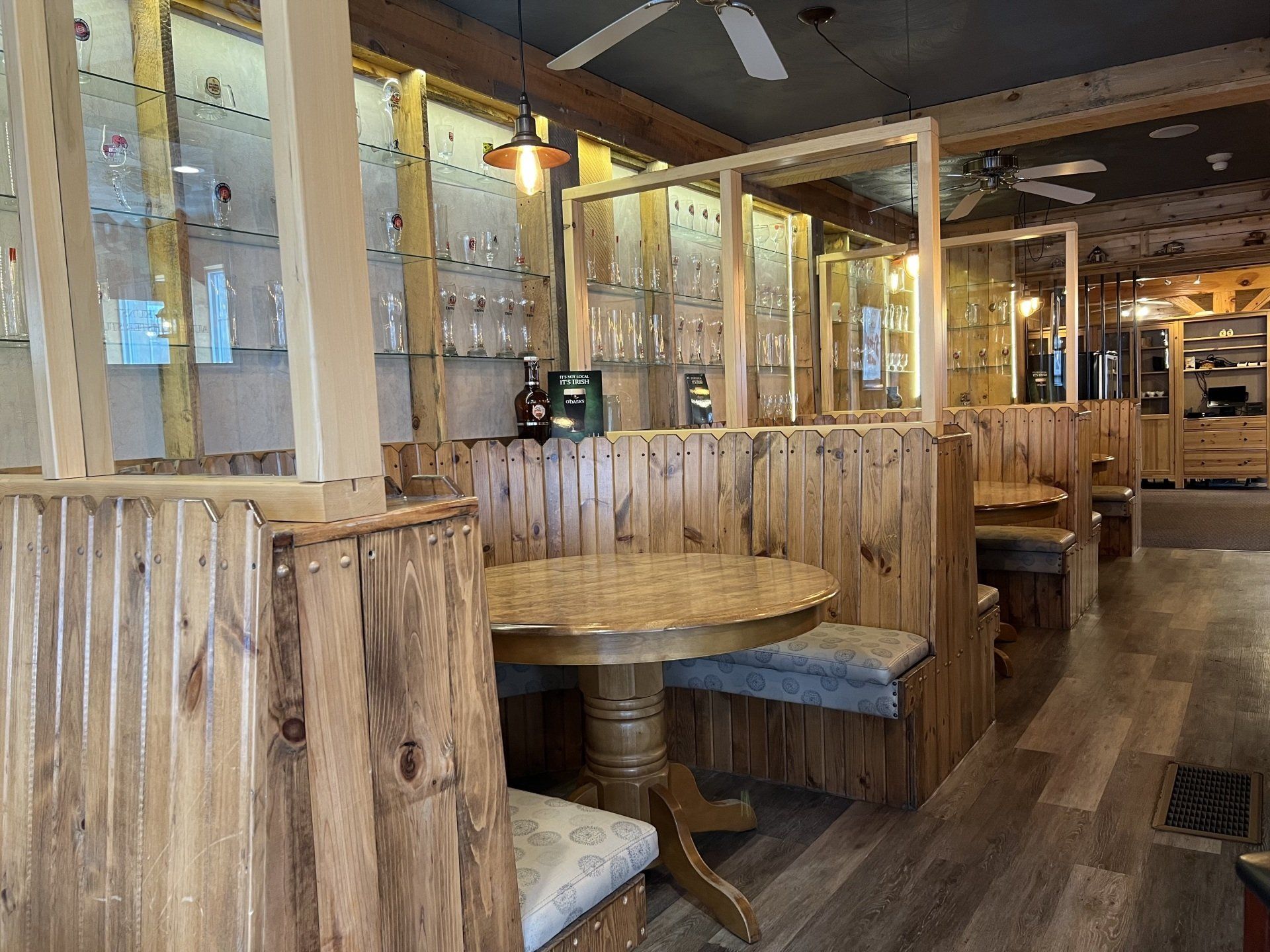 Rustic restaurant booth with wooden tables, benches, and string lights indoors