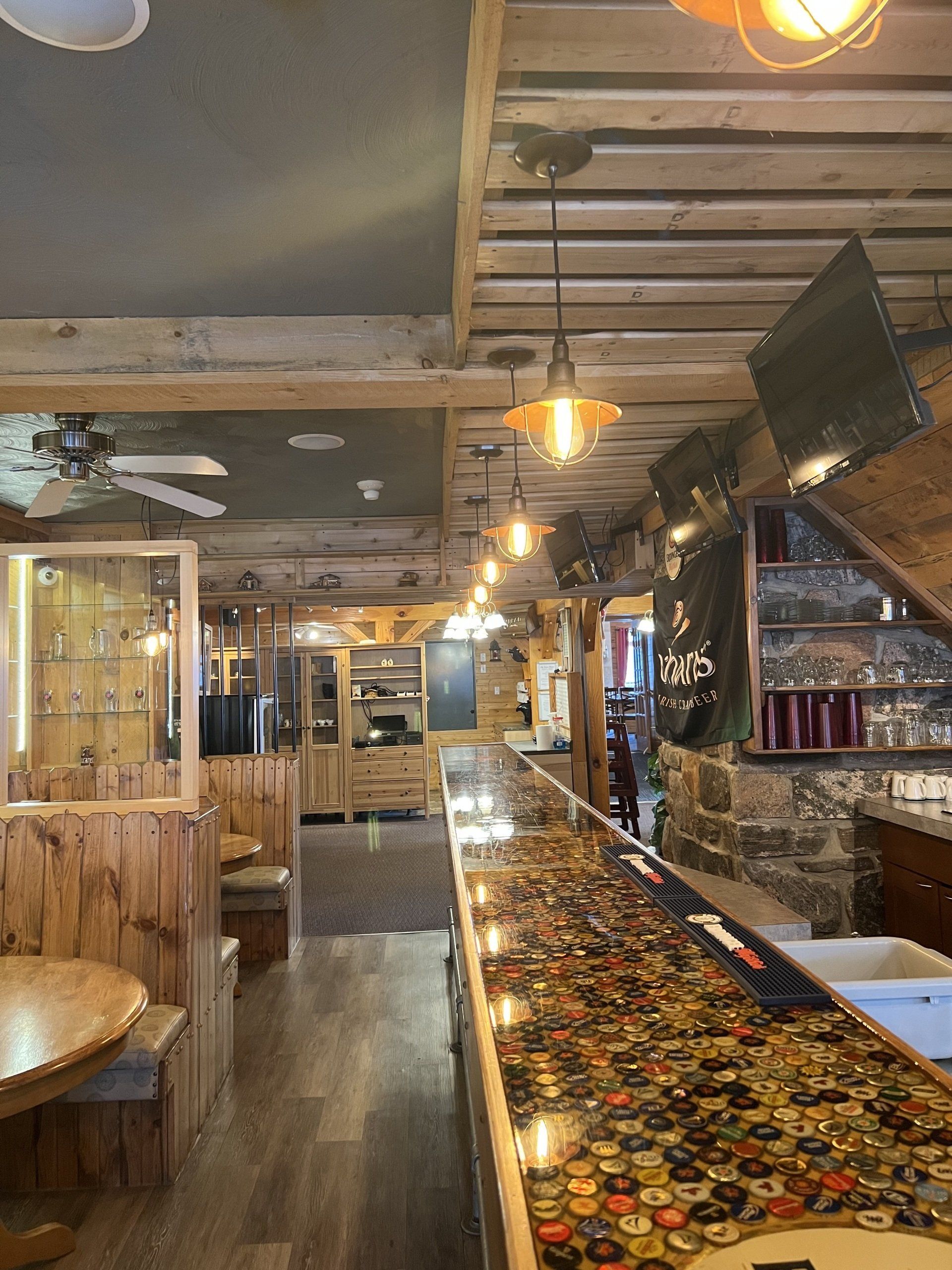 Rustic bar interior with wooden seating, hanging lights, and a long patterned counter