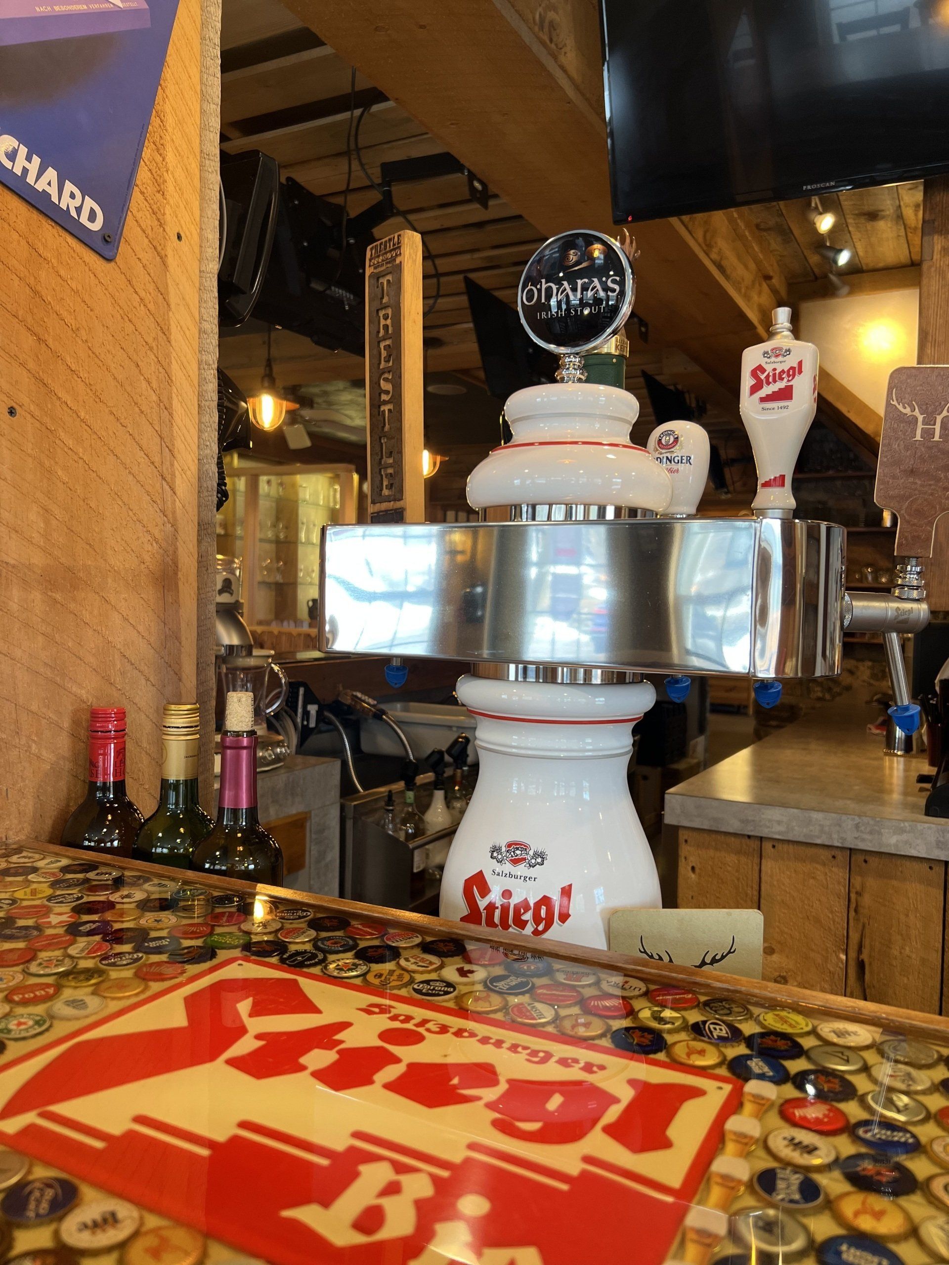 Robot waiter carrying drinks in a bar with red-and-white decor and a tiger logo mat