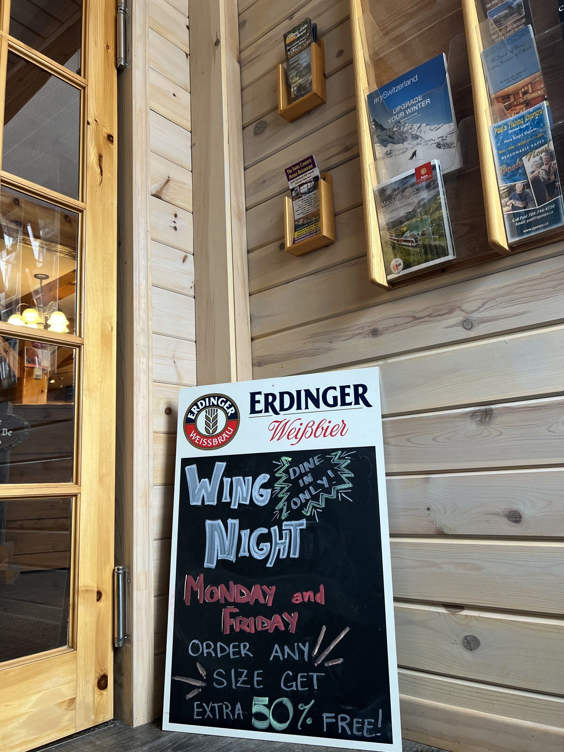 Pub sign outside with chalkboard reading “Wine Night” and “FREE” beside a wooden doorway