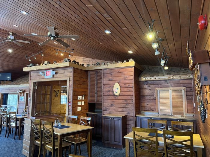 Rustic restaurant interior with wooden tables, brick walls, and ceiling lights