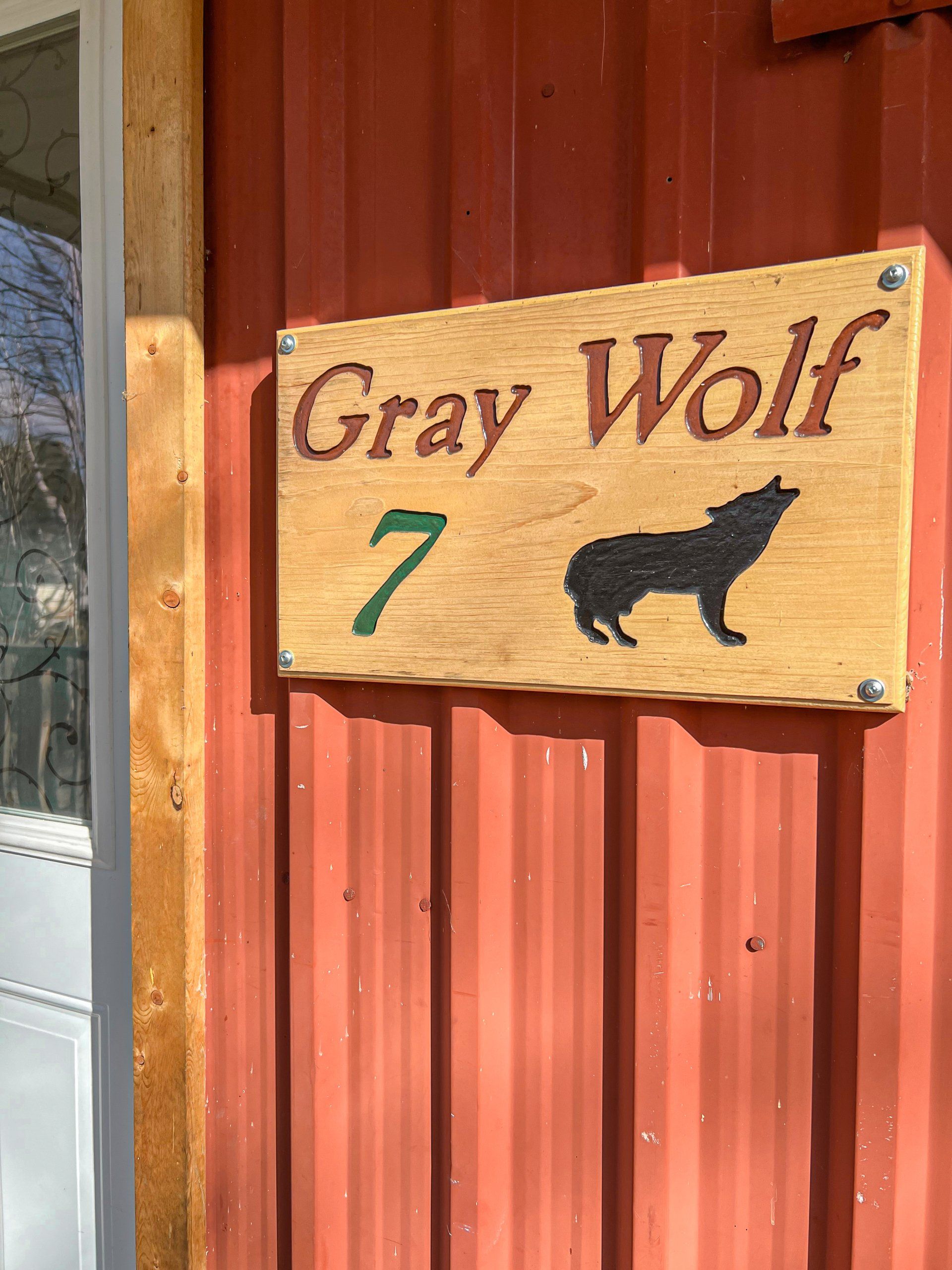 Gray Wolf sign with number 7 and wolf silhouette on a red wooden wall
