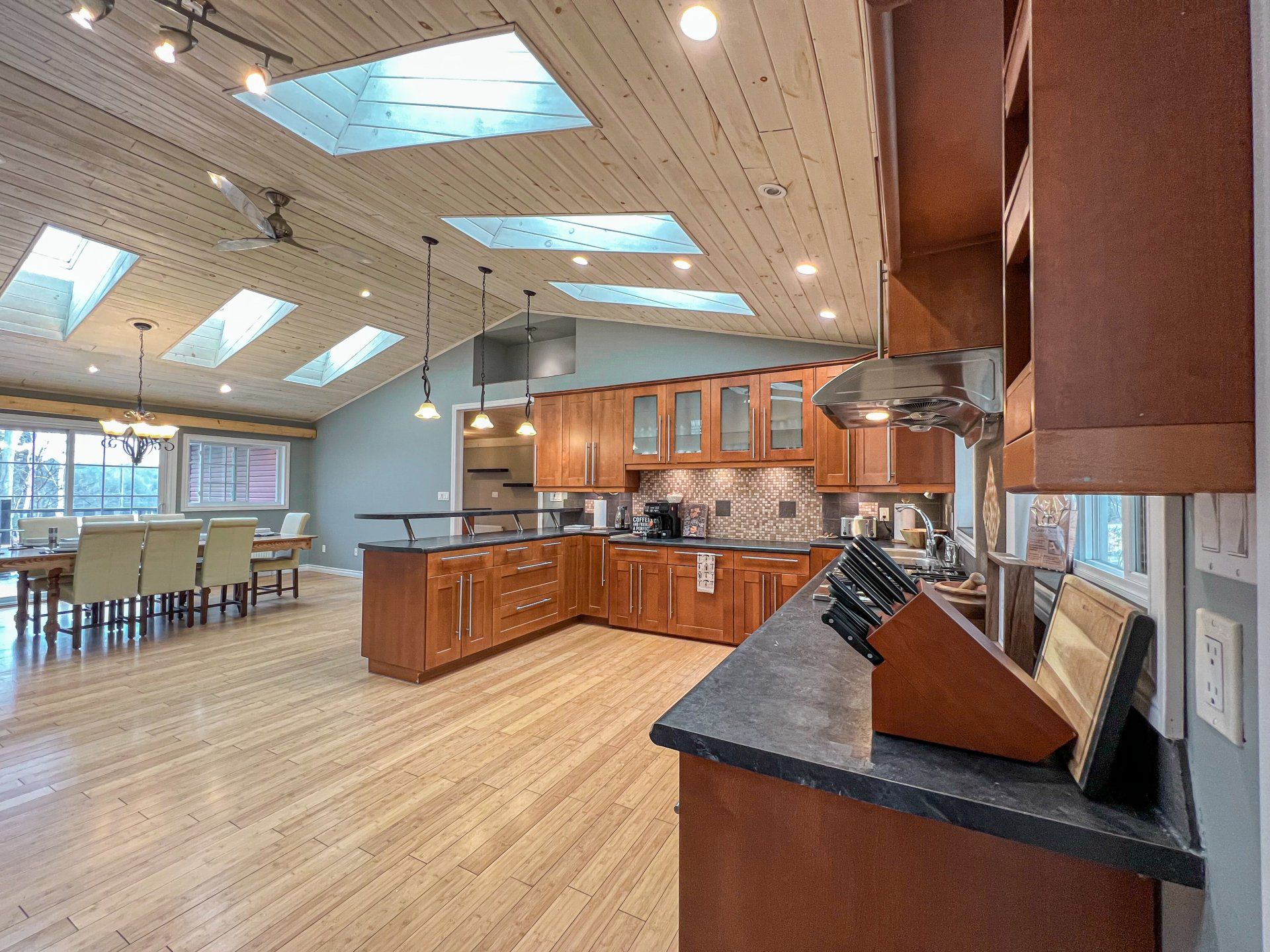 Spacious modern kitchen with wood cabinets, large island, and skylight-lit dining area