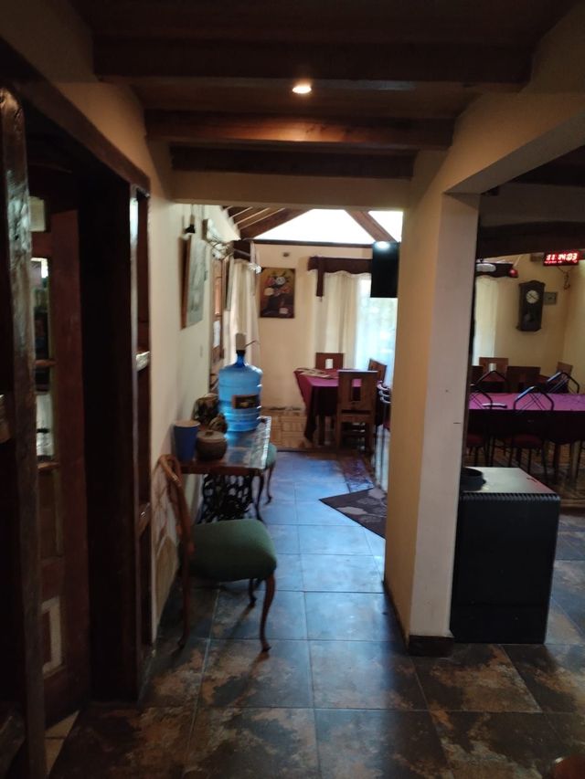 Un pasillo con una mesa y sillas y una mesa de billar.