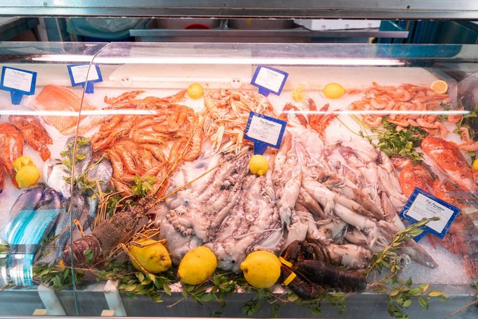 Piatto di frutti di mare fritti e spicchi di limone su un rustico tavolo di legno.