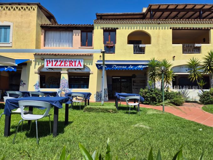 Pizza Margherita con foglie di basilico su un piatto, servita su un tavolo
