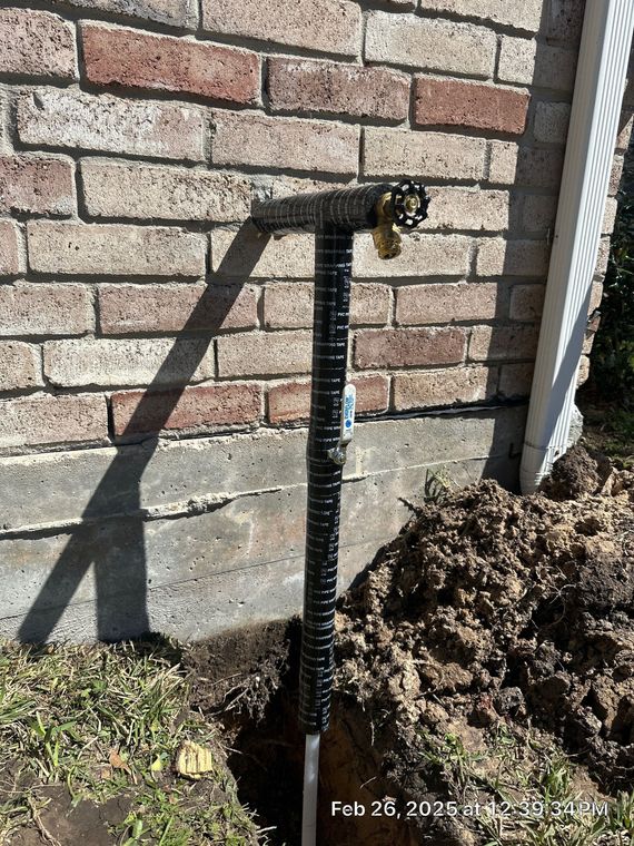 Technician inspecting plumbing pipes with a handheld camera in a utility space