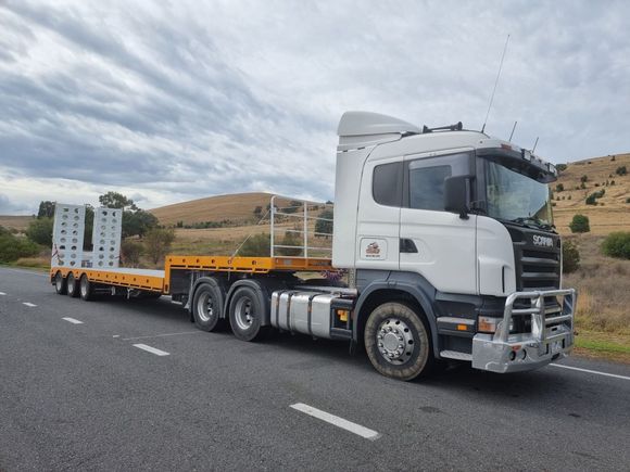 bobcat machines being transported on a flatbed truck