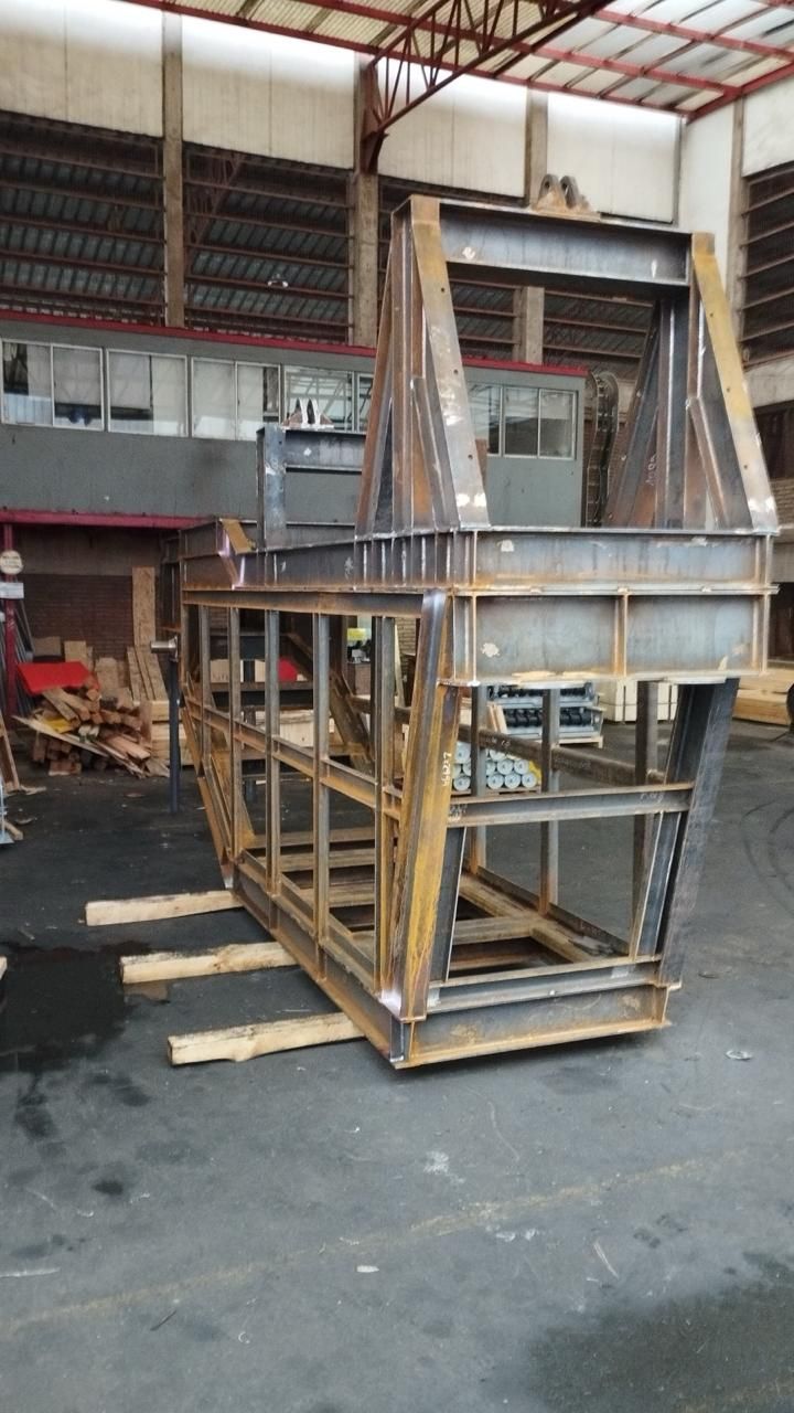 Bastidor de acero de una estructura grande, posiblemente la carrocería de un vehículo, en un taller. 