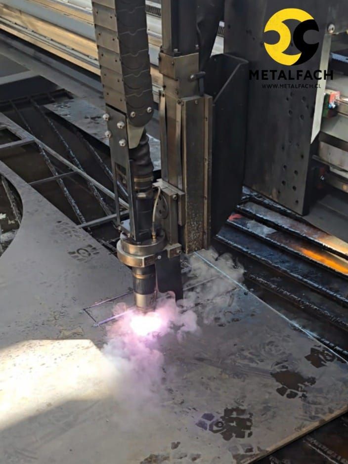 Cortadora de plasma cortando chapa metálica; se ven chispas y humo. Logotipo de Metal Fach a la derecha.