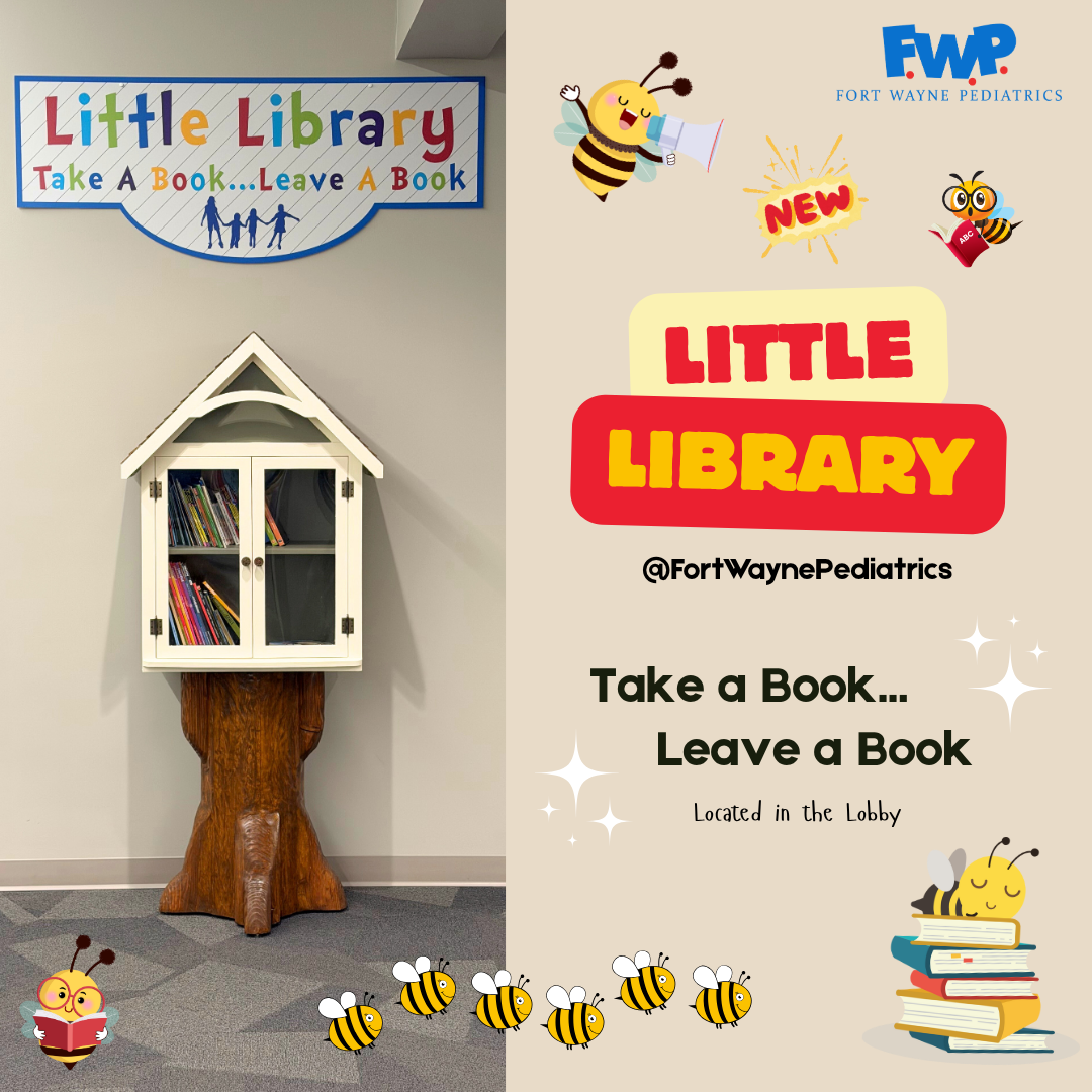 Little library on a tree trunk sign, with books inside and “Take a Book, Leave a Book” text and bee decorations