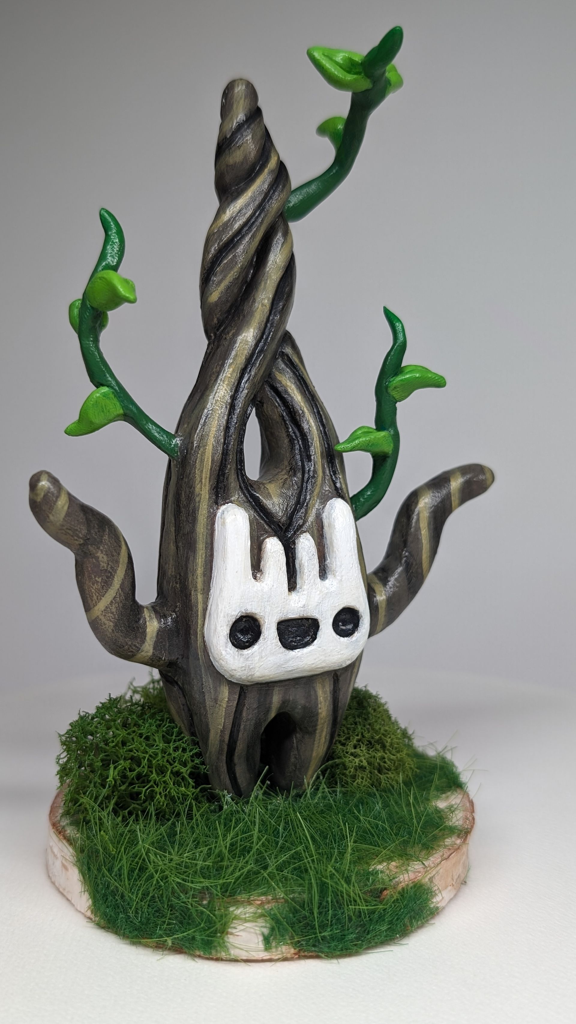 A statue of a tree with a bunny face on it.