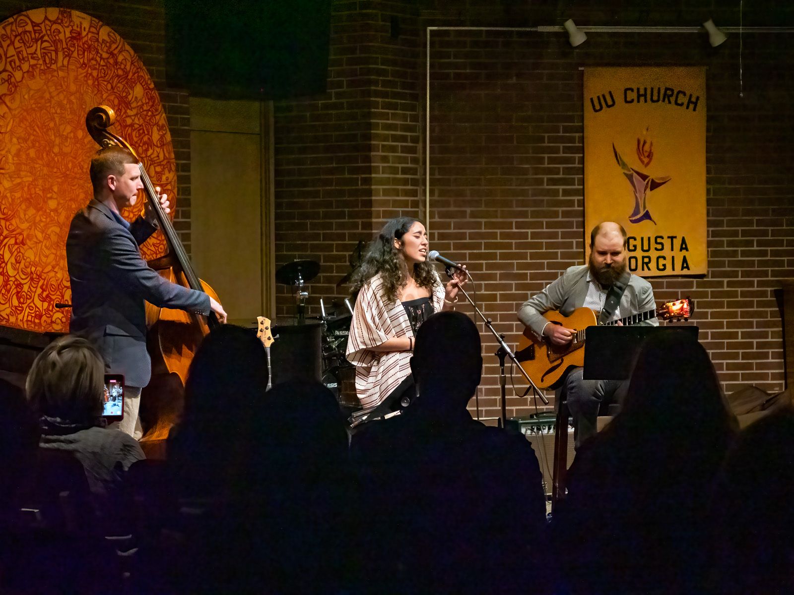 A group of people are playing instruments on a stage in front of a crowd.