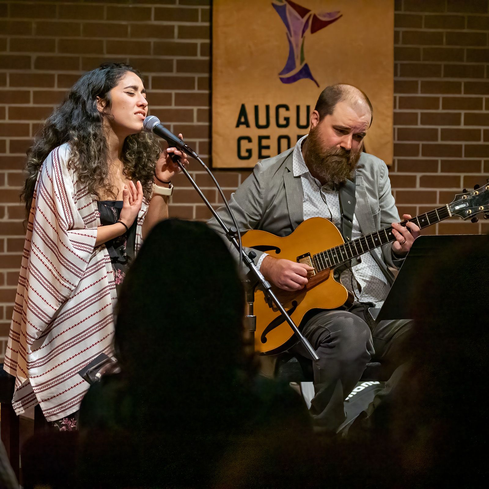 A man playing a guitar and a woman singing