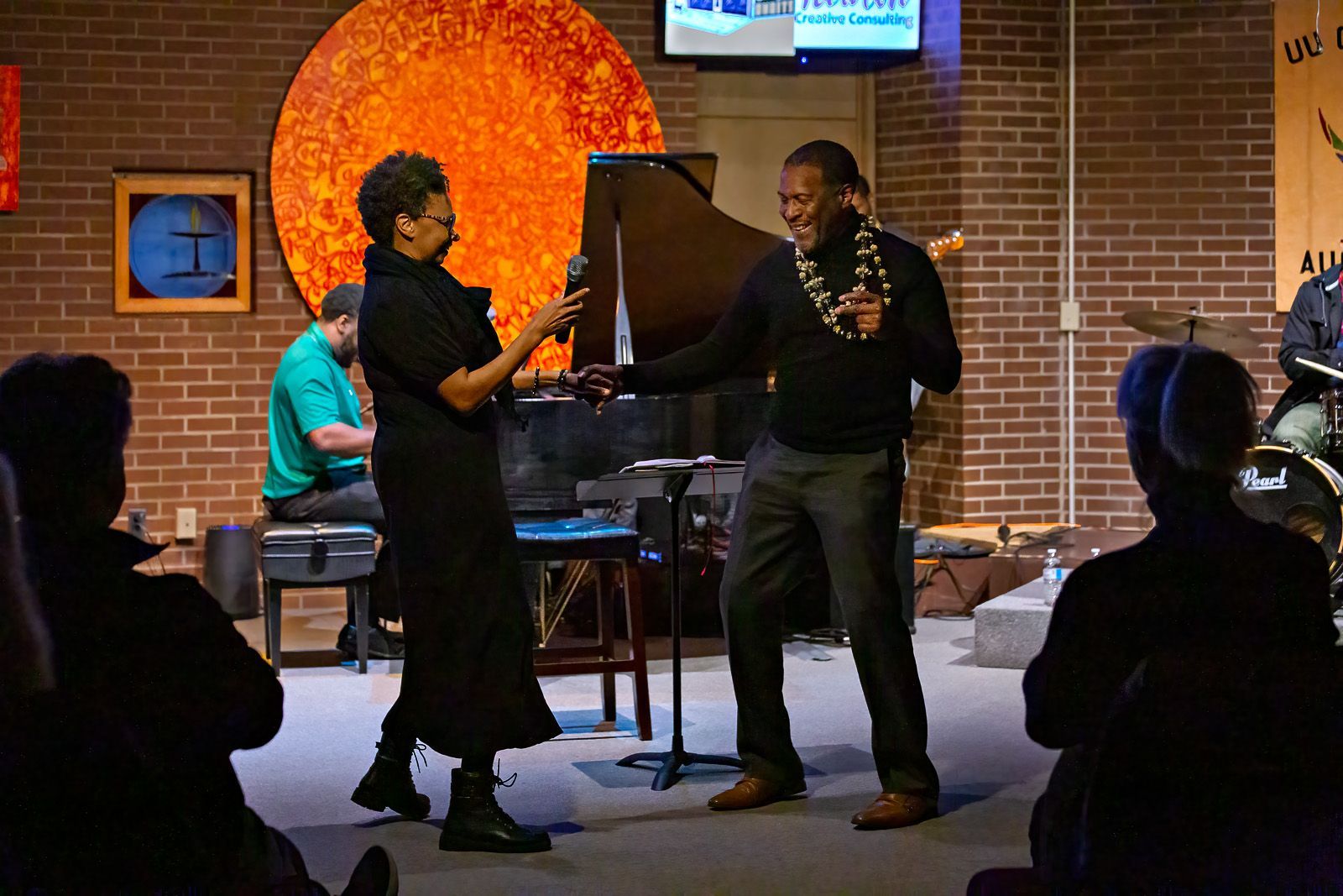 A man and a woman are dancing in front of a crowd