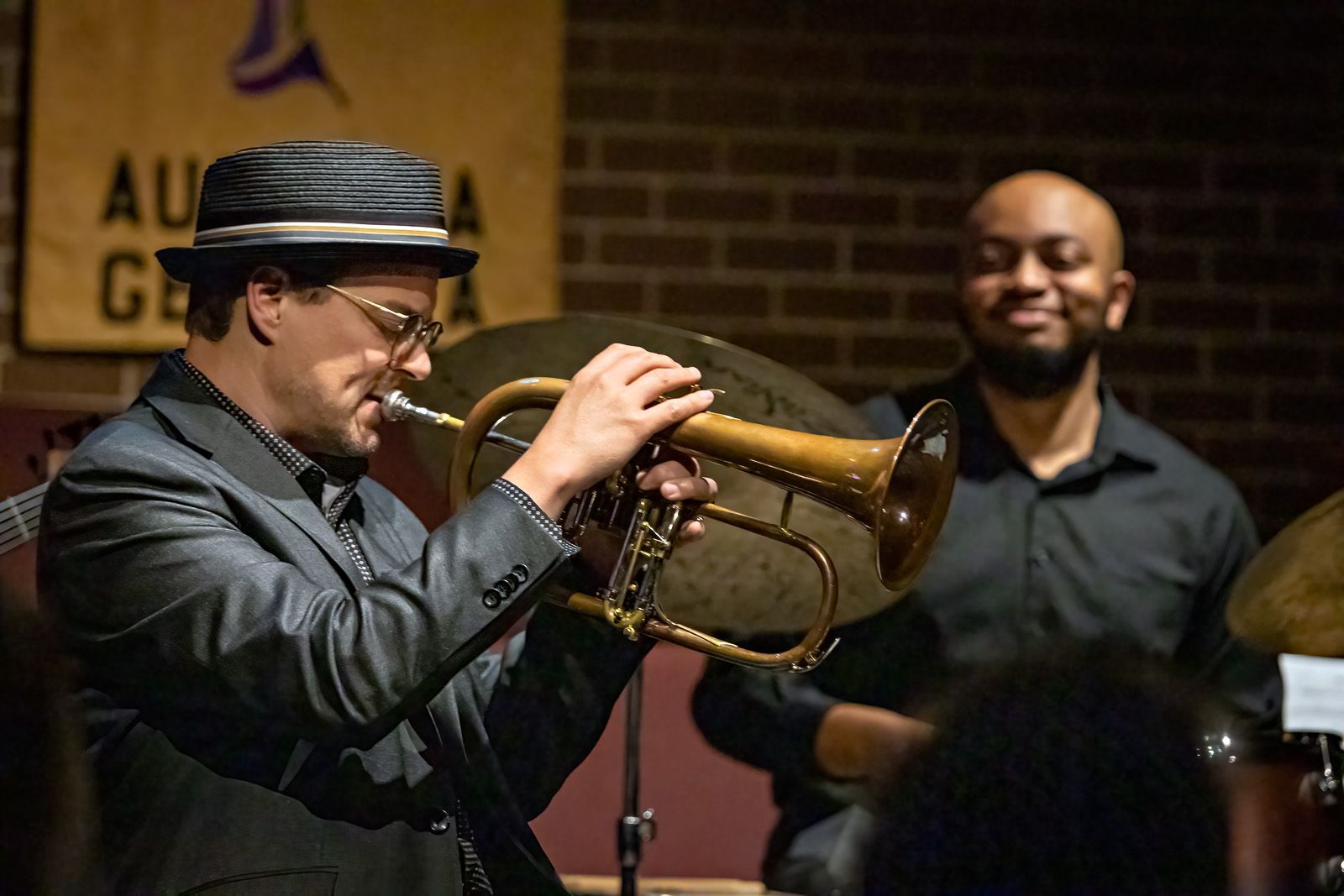 A man in a hat is playing a trumpet