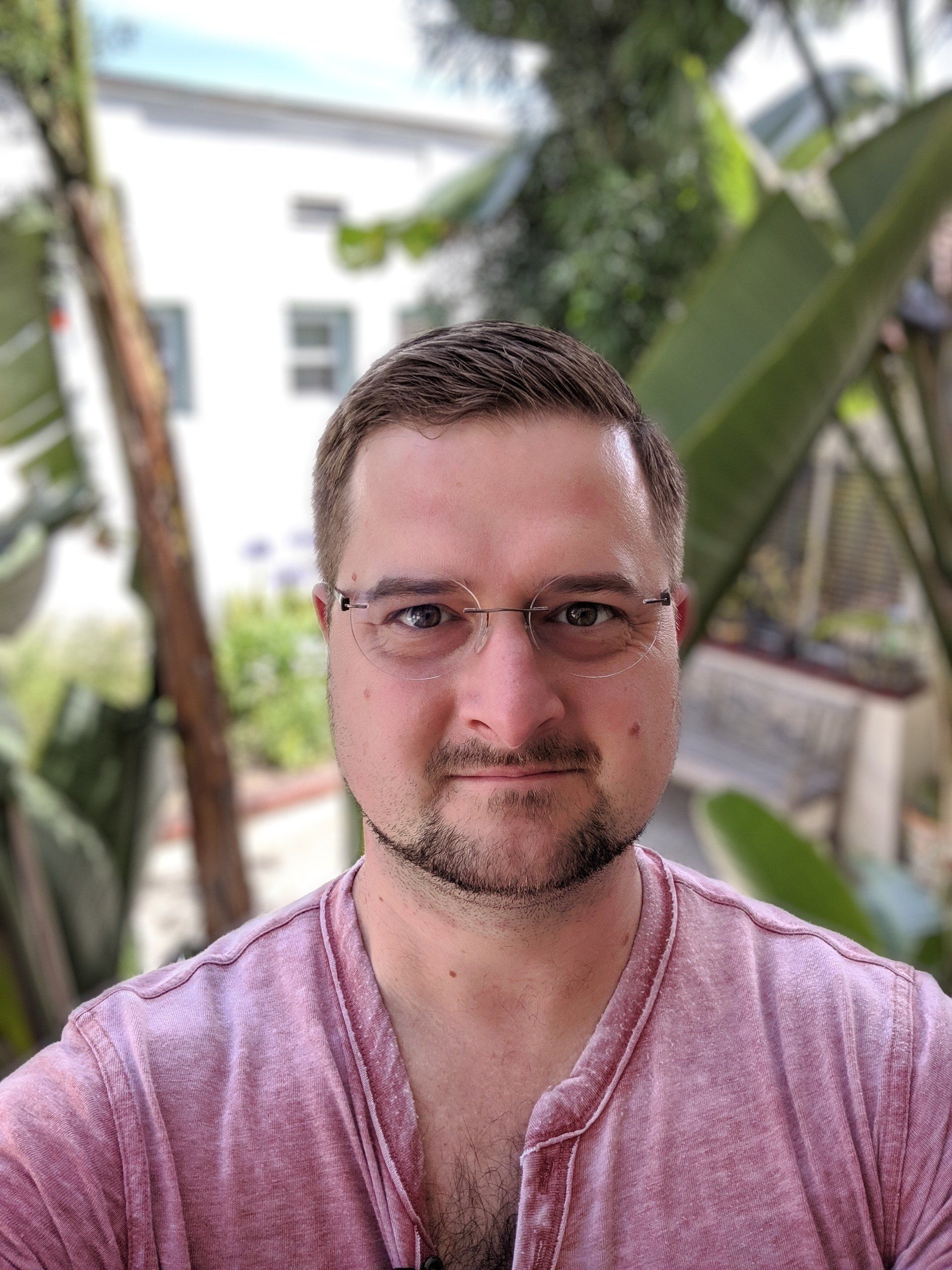 A man wearing glasses and a pink shirt