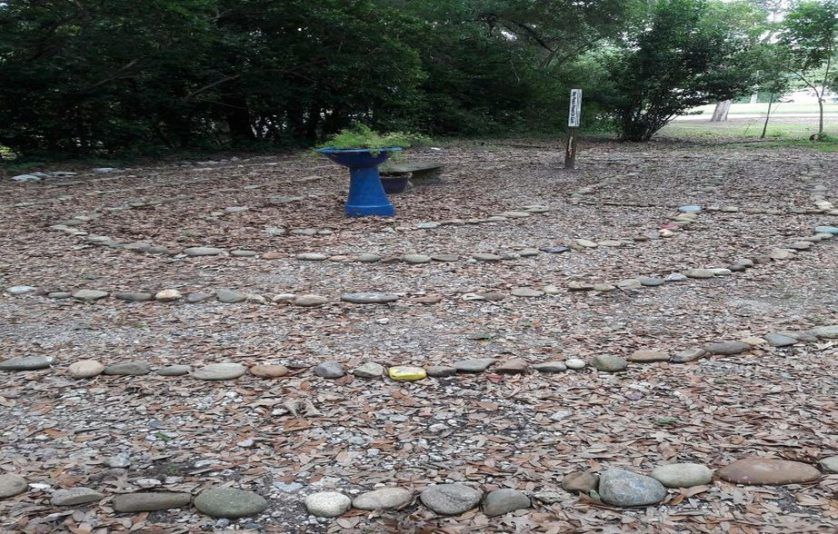 A labyrinth made of rocks and leaves in a park