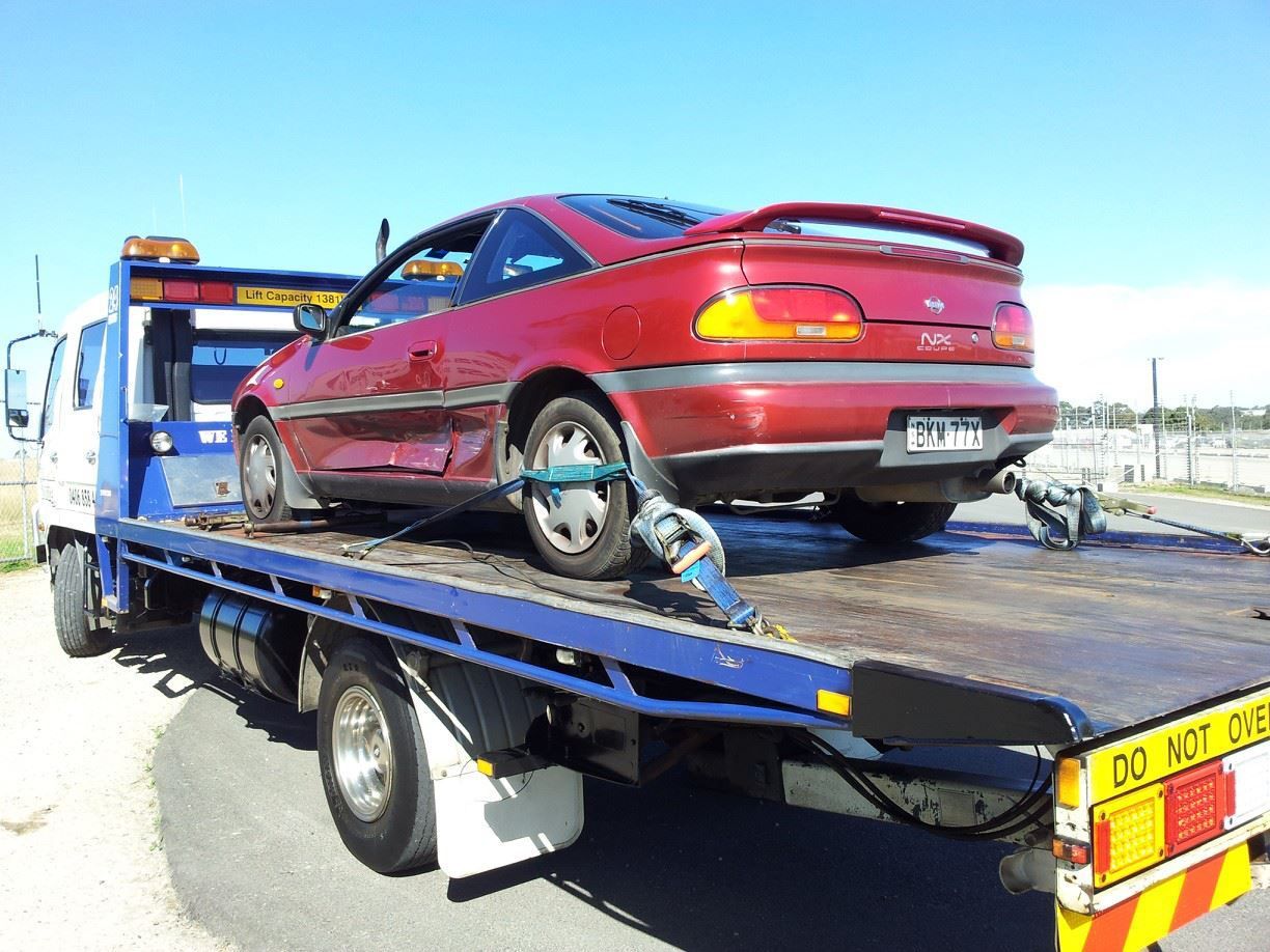 A Red Car Is on The Back of A Tow Truck — Twin Lakes Towing & Recovery in East Maitland, NSW