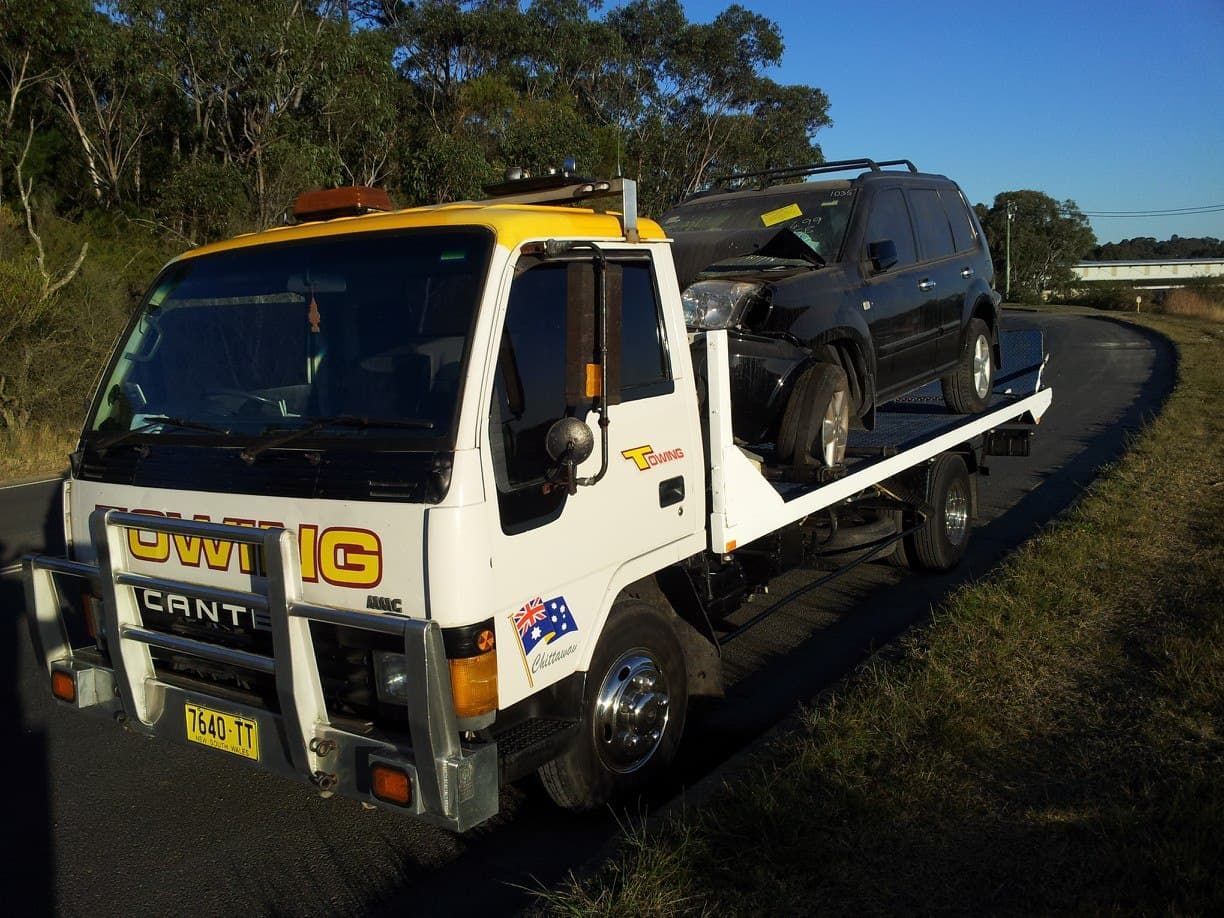 A White and Yellow Tow Truck Carrying a Black Suv — Twin Lakes Towing & Recovery in Kurri Kurri, NSW