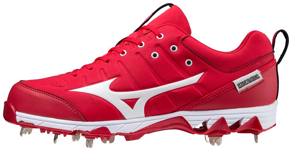 A pair of red and white baseball cleats on a white background.