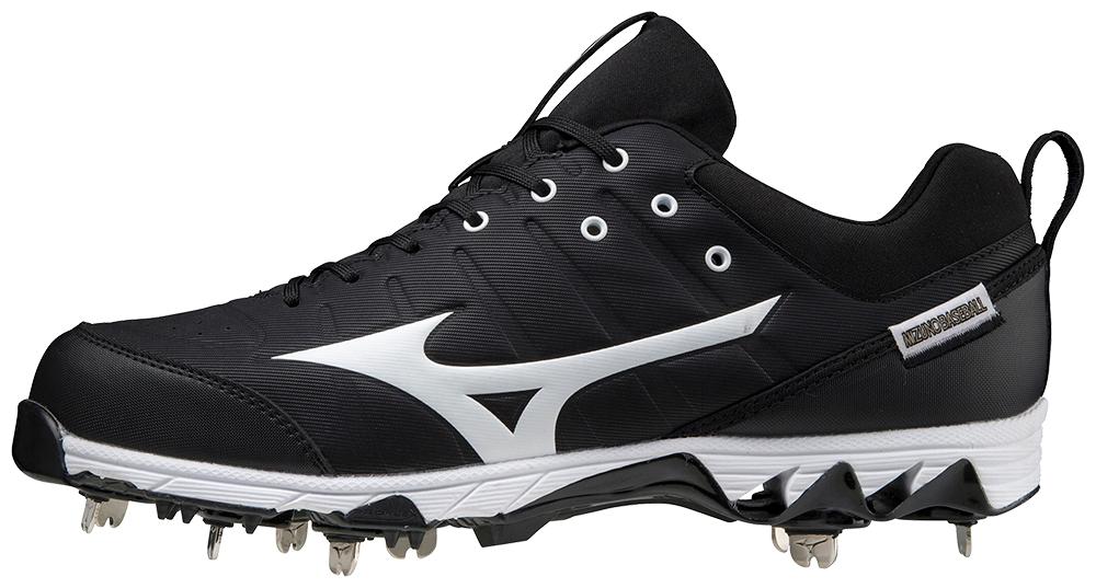 A pair of black and white baseball cleats with metal spikes on a white background.
