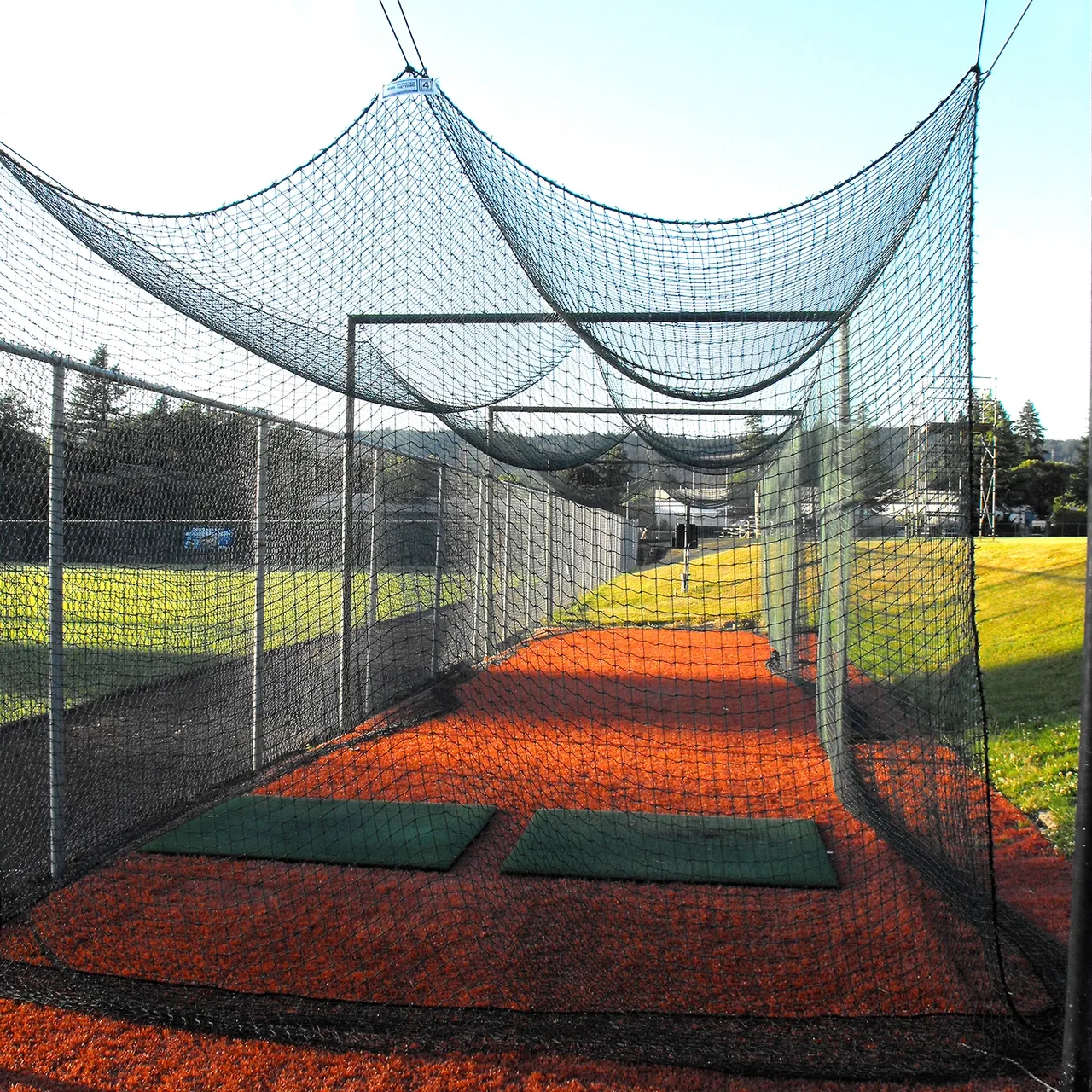 A batting cage with a fence surrounding it