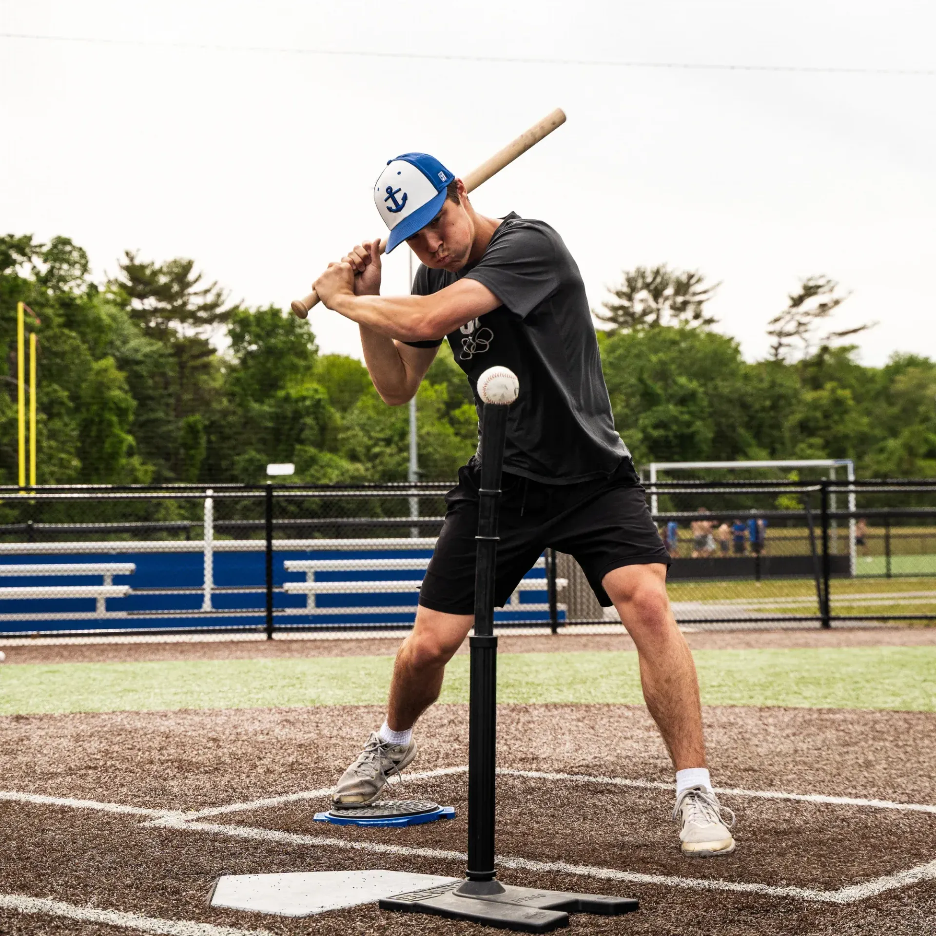 A man is swinging a baseball bat at a ball on a baseball field.