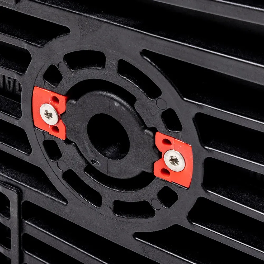A close up of a black grille with two red screws on it