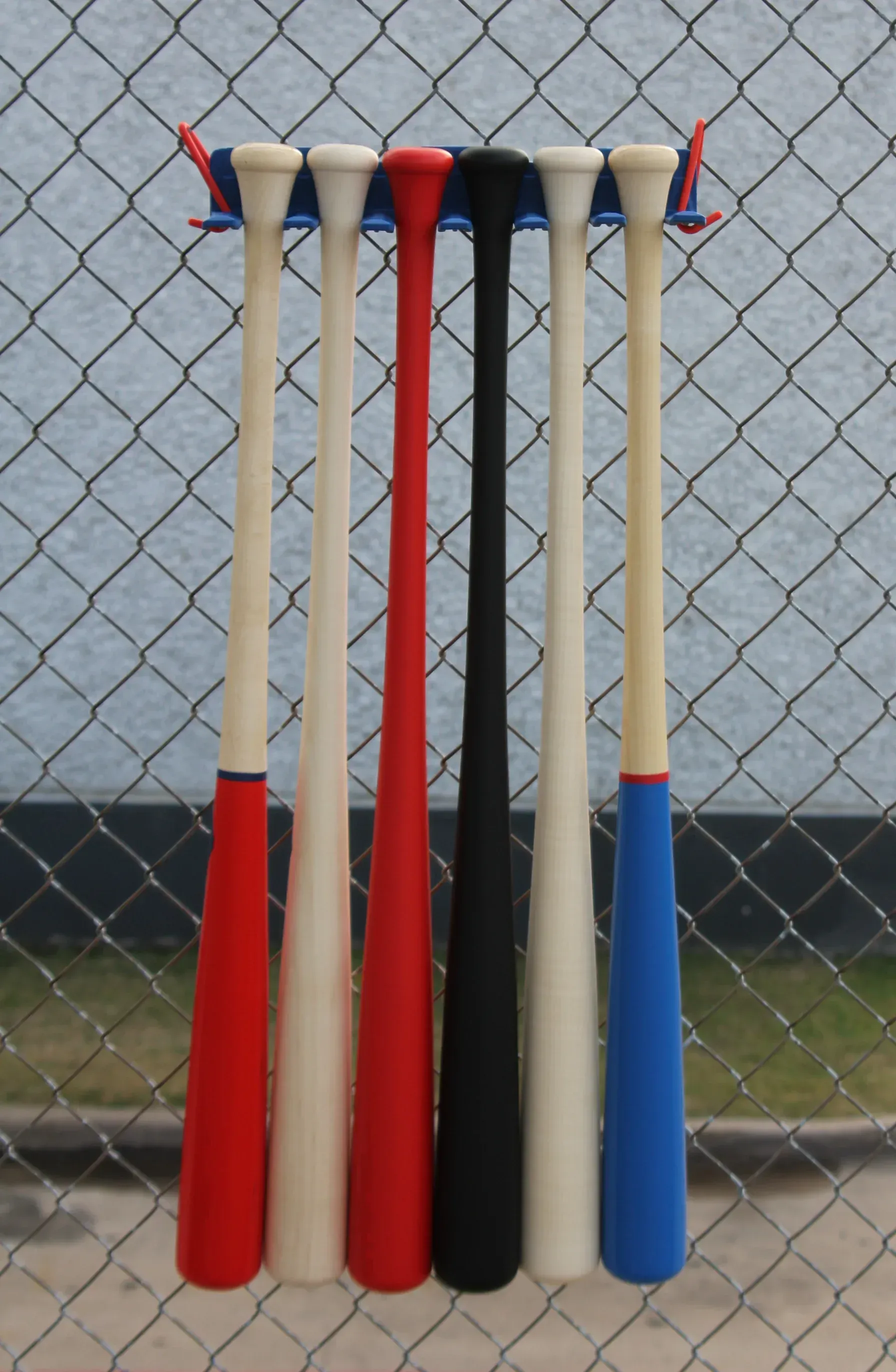 A bunch of baseball bats hanging on a rack