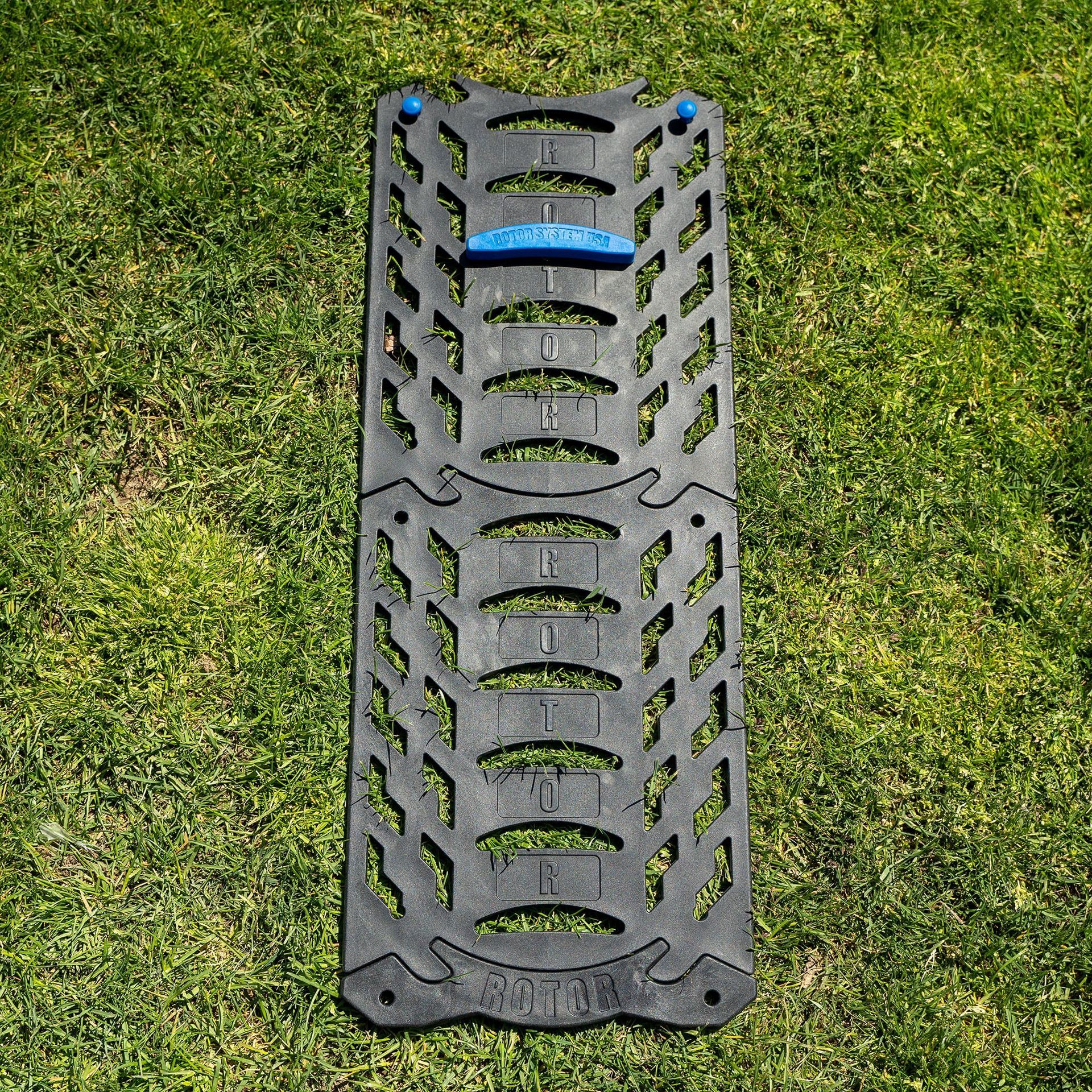 A black tire shaped object is sitting on top of a lush green field.