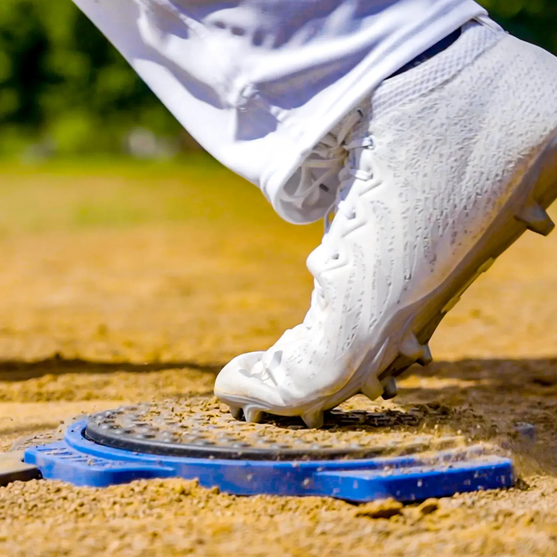 A close up of a person 's foot wearing white cleats