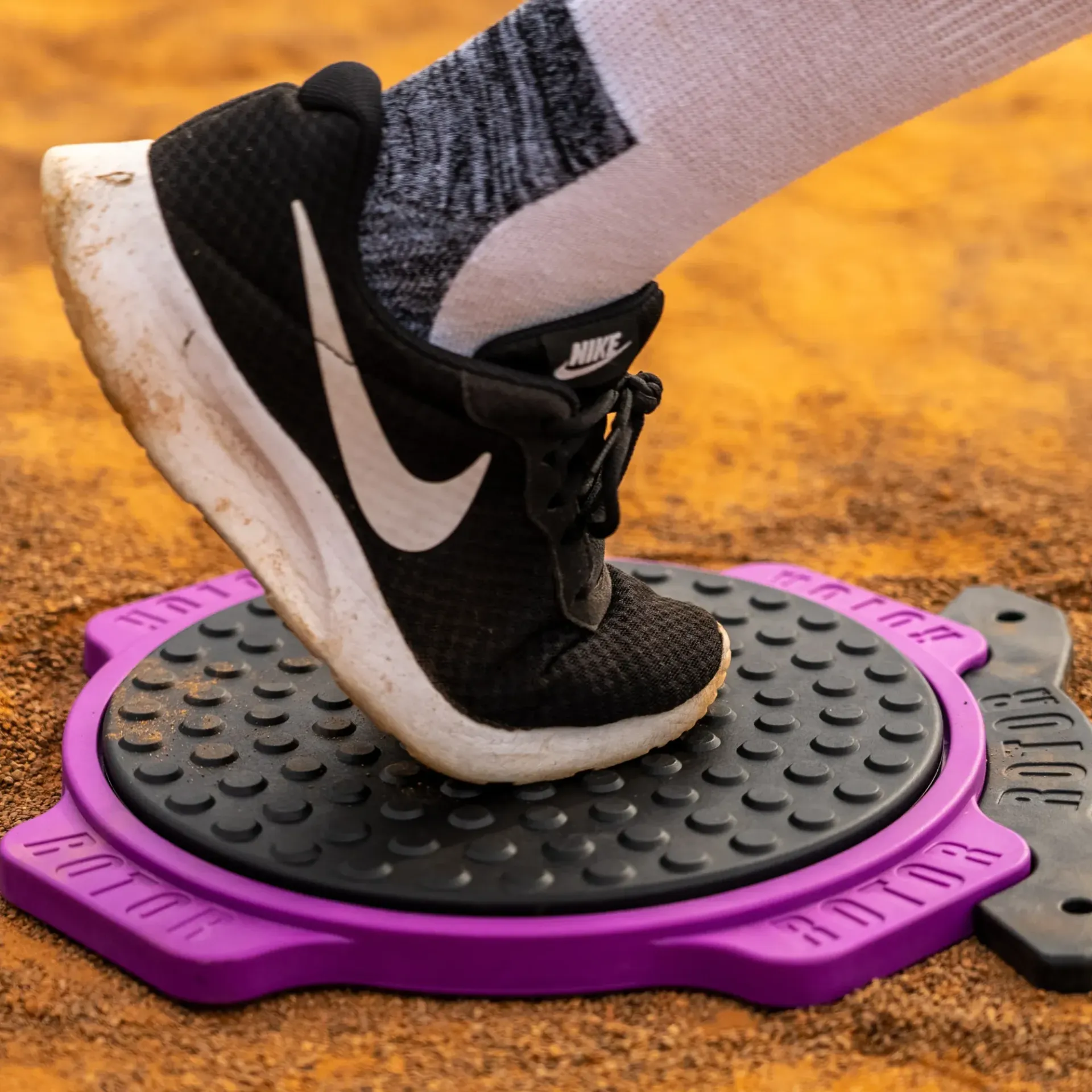 A person wearing nike shoes is standing on a purple mat