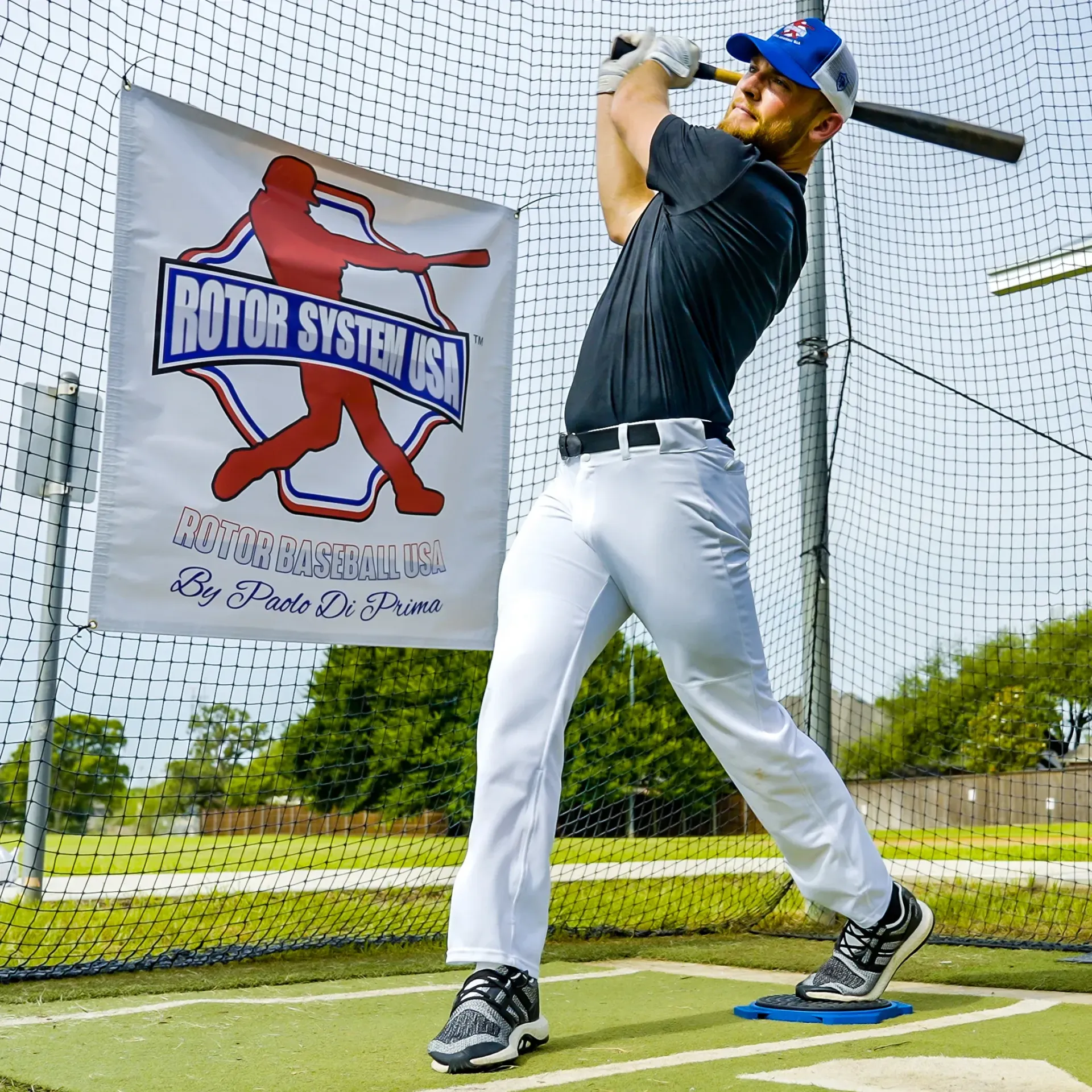 A man is swinging a bat in front of a motor system sign